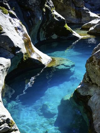 Don't just go to Switzerland! Deep in the cursed mountains of Albania lies a secluded town with only stone houses, the Blue Eye Spring of fairies, and medieval spirits.