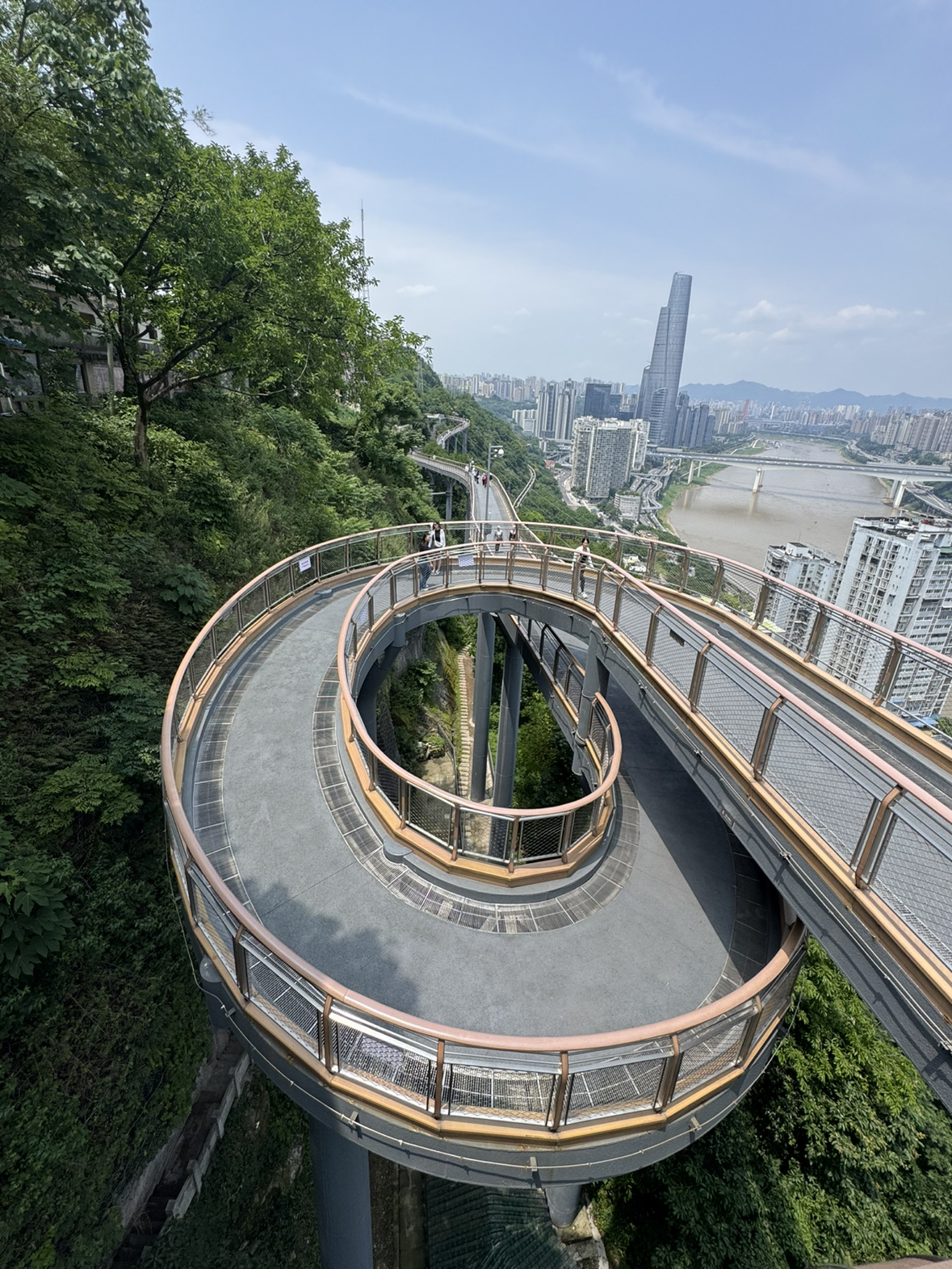 Taman Eling adalah salah satu lokasi terbaik untuk melihat Chongqing dari ketinggian dan menyadari betapa uniknya tata kota serta skala kota ini.

Tak jauh dari sana, ada Jembatan Elingzhan — sebuah jembatan pejalan kaki modern yang menawarkan spot foto dan pemandangan gedung-gedung pencakar langit.

Keduanya memberikan kesan yang mendalam, apalagi jika dikunjungi pada malam hari.

⸻

Tamannya sendiri berada di atas bukit, jadi pemandangan kota yang indah sudah bisa dinikmati bahkan saat dalam perjalanan menuju ke sana.

Tempat ini tidak terasa seperti "objek wisata" yang komersial — lebih seperti taman kota biasa yang tiba-tiba menyuguhkan panorama megah metropolis.

⸻

🎟 Biaya
	· Masuk taman biasanya gratis
	· Beberapa menara atau area tertentu mungkin berbayar

⸻

📍 Cara ke sana

Pilihan paling praktis:
	· Metro Jalur 1 ke Stasiun Eling
	· Lanjut jalan kaki sekitar 5–10 menit

💡 Medannya berbukit, jadi bersiaplah untuk menaiki banyak tangga dan tanjakan.

⸻

🏞 Pengalaman saya

Saya datang menjelang sore, dan ternyata itu adalah waktu yang paling pas.

Saat masih terang, kita bisa melihat kontur kota dan gedung-gedung tak berujung di atas perbukitan. Setelah matahari terbenam, Chongqing mulai bercahaya dan suasananya terasa sangat futuristik.

Pemandangannya terlihat sangat cantik dari Jembatan Elingzhan.

⸻

🌆 Apa yang menarik
	· Panorama kota
	· Perpaduan area hijau dan gedung pencakar langit
	· Cahaya lampu di malam hari
	· Sensasi Chongqing yang "bertingkat-tingkat"
	· Relatif tidak terlalu ramai turis

⸻

💡 Tips praktis
	· Sebaiknya datang 1–1,5 jam sebelum matahari terbenam
	· Sepatu yang nyaman adalah keharusan — banyak tangga
	· Setelah hujan, pemandangan mungkin berkabut, tapi itu justru menambah suasana
	· Alokasikan waktu 1,5–2 jam
	· Suhu di ketinggian bisa terasa lebih dingin saat malam hari

⸻

Taman Eling dan Jembatan Elingzhan adalah kombinasi terbaik antara taman dan tempat melihat pemandangan di Chongqing.

Jika kamu ingin melihat kota tidak hanya dari bawah, tapi juga merasakan kemegahannya dari atas — tempat ini sangat luar biasa.