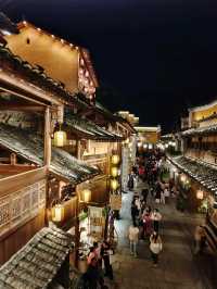 Wangxian Valley: Night Market Lights Reflecting Visitors