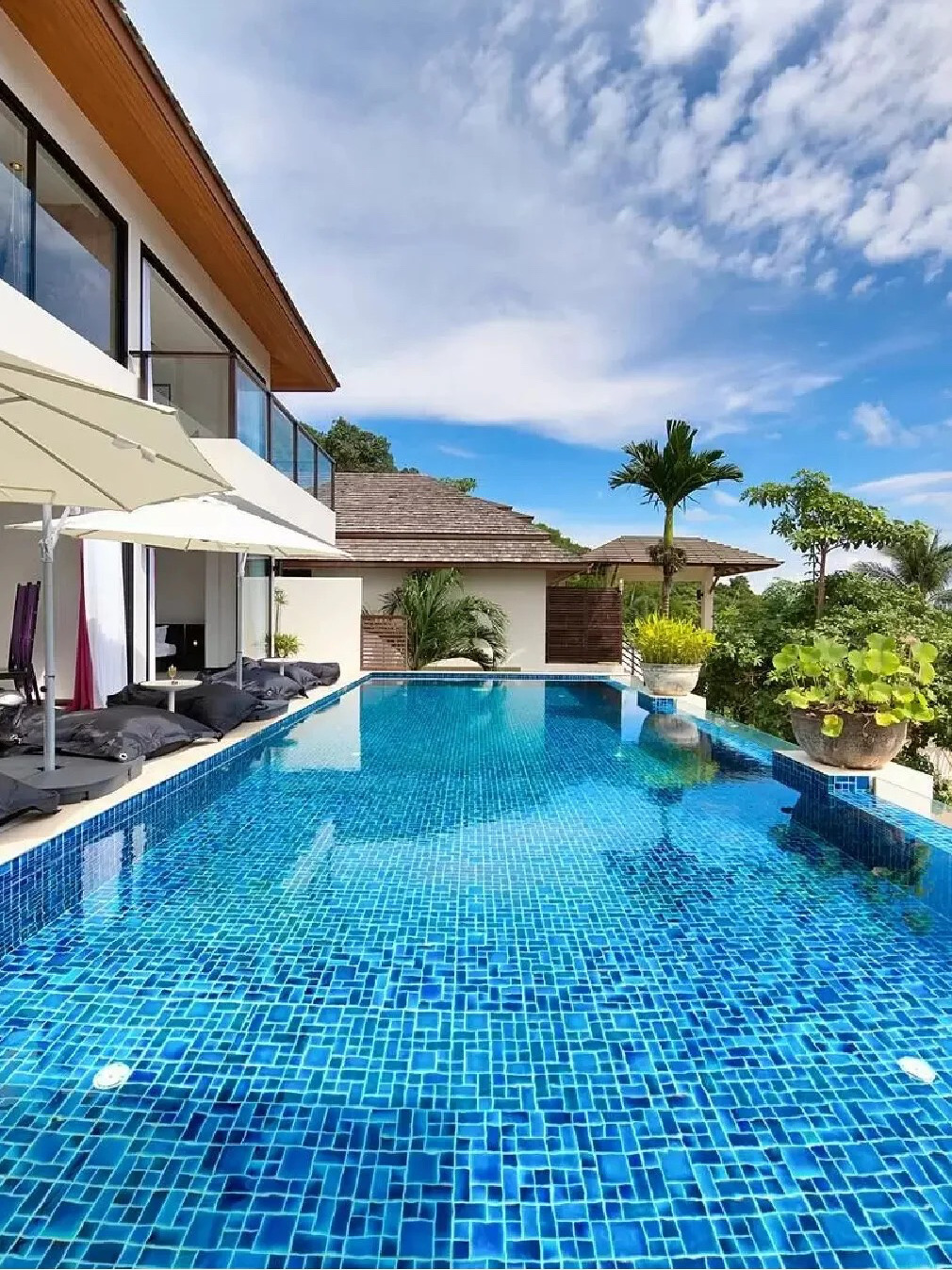 🌴 3-Story Villa with Ocean Views on Koh Samui – Perfect for Families
🏡 "Baan Maliwan" is a 3-story villa located within the Dhevatara Residence Estate, offering stunning ocean views. This villa boasts 693 square meters of living space and is just 130 meters from the beach and a 6-minute drive from Fisherman’s Village.

· Accommodates 4–8 guests
· 2–3 bedrooms
· 2.5–3.5 bathrooms
· 693 square meters of living space

💡 Highlights:
1️⃣ 693 sq m hillside villa with stunning ocean views
2️⃣ Located within the Dhevatara Residence Estate, just 130 meters from Bo Phut Beach
3️⃣ Relax on loungers by the 12-meter swimming pool
4️⃣ Professional on-site service, including a private chef (additional charges apply)
5️⃣ Kayaks, yoga mats, and BBQ grill available (Optional)
6️⃣ Conveniently located just 6 minutes from Fisherman’s Village.

🎄 Relax in comfort in the spacious, air-conditioned living and dining area, which opens onto an outdoor terrace furnished with beanbag chairs. You can also take a dip in the 12-meter swimming pool while enjoying ocean views.

🛌🏻 The villa is designed in a pavilion style, with each bedroom decorated in a contemporary tropical style and featuring an en-suite bathroom. One bedroom has direct pool access, while two others are located on the top floor offering stunning views. The largest bedroom boasts a private balcony and a bathtub with ocean views.

🍶 The kitchen is fully equipped with modern appliances and features a central counter that doubles as a breakfast bar. A private chef service is available to prepare delicious meals (additional cost applies). Kayaks, yoga mats, and BBQ equipment are also available for guests. You can request to use this service.

🍀 Although the coastline in front of Dhevatara Residence Estate is rocky, you can walk along the shore for just 200 meters to find a beach where you can swim.
#OceanViewVilla #BeachGetaway #ResortVacation #KohSamuiVilla #KohSamuiTravel #KohSamuiVacation #ThailandTravel