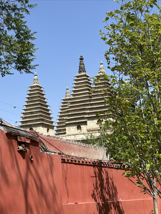 Keheningan menyelimuti begitu Anda membuka pintu: Permata tersembunyi dari Kuil Lima Pagoda dengan dinding merah dan pagoda batunya.