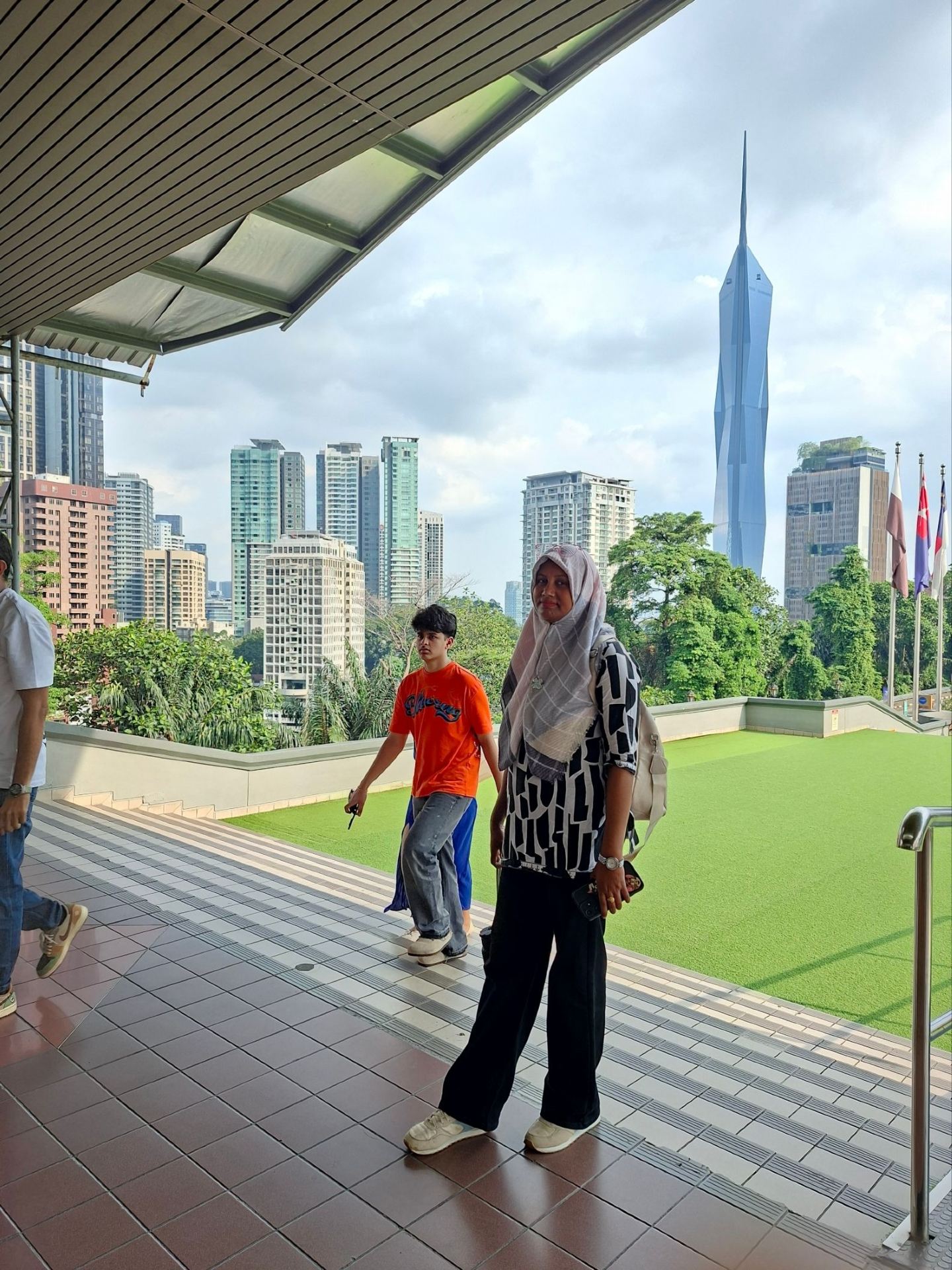 A Beautiful Family Moment Beneath the Iconic KL Tower 🇲🇾✨

Standing beneath the magnificent Kuala Lumpur Tower (KL Tower), surrounded by Kuala Lumpur’s modern skyline and lush greenery, this moment feels like a beautiful meeting point between family, travel, nature, and Malaysia’s rich heritage. ❤️📸

The Kuala Lumpur Tower, also known as Menara KL, is one of Malaysia’s most recognizable landmarks. Rising 421 metres above the ground, the tower was designed not only as a telecommunications and broadcasting centre, but also as a symbol of Malaysia’s technological progress, architectural creativity, and national identity. Construction began in the early 1990s, and the tower officially opened to the public on 23 July 1996, before its official launch on 1 October 1996.

🌿 Where Modern Kuala Lumpur Meets Nature

One of the most fascinating things about KL Tower is its location on Bukit Nanas, an area associated with one of Kuala Lumpur’s precious pockets of tropical rainforest. This creates a remarkable contrast: a 421-metre modern tower rising above a green landscape in the heart of a busy metropolitan city.

From the tower, visitors can enjoy spectacular views across Kuala Lumpur. The Observation Deck is around 276 metres above ground, while the Sky Deck reaches approximately 300 metres, offering an impressive panoramic perspective of the city.

🕌 A Touch of Malaysian Heritage in Modern Architecture

KL Tower is more than steel, concrete and glass. Its design incorporates Islamic artistic influences and geometric motifs, reflecting Malaysia’s Islamic heritage while embracing modern engineering and Western technological innovation. Even the interior design of the main lobby incorporates the traditional Islamic Muqarnas decorative concept.

This combination beautifully represents Kuala Lumpur itself—a city where Malay, Chinese, Indian and other cultural influences live side by side, while historic traditions continue alongside modern skyscrapers, shopping centres and world-class infrastructure. Tourism Malaysia describes Kuala Lumpur as a city where historic monuments, mosques, temples, parks and futuristic skyscrapers form one vibrant urban landscape.

📸 A Memory Beyond a Photograph

The smiles, the beautiful surroundings, the Malaysian flags and the towering KL Tower in the background make these photographs more than ordinary travel pictures. They capture a special family moment in one of Kuala Lumpur’s most iconic locations.

Sometimes a journey is not simply about reaching a destination—it is about the people beside us, the places we discover together, and the memories we carry home.

KL Tower stands proudly above Kuala Lumpur, but moments like these are what truly make a journey unforgettable. ❤️🇲🇾

#KLTower  #MenaraKL  #KualaLumpur  #Malaysia  #VisitMalaysia  #MalaysiaTravel  #TravelMemories  #FamilyTravel  #KualaLumpurSkyline  #MalaysiaHeritage  #TravelPhotography  #BeautifulMoments  #BukitNanas  #ExploreMalaysia 