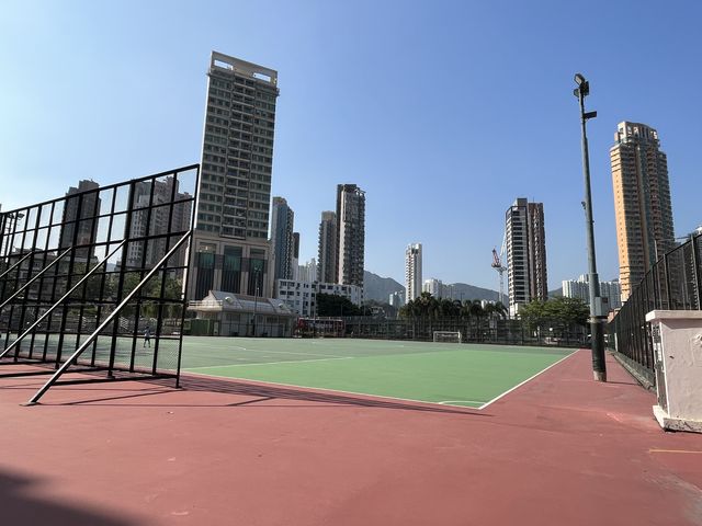 車來車往交通迴旋處旁邊嘅一個硬地足球場