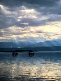 雲起邛海上，泛舟水天間