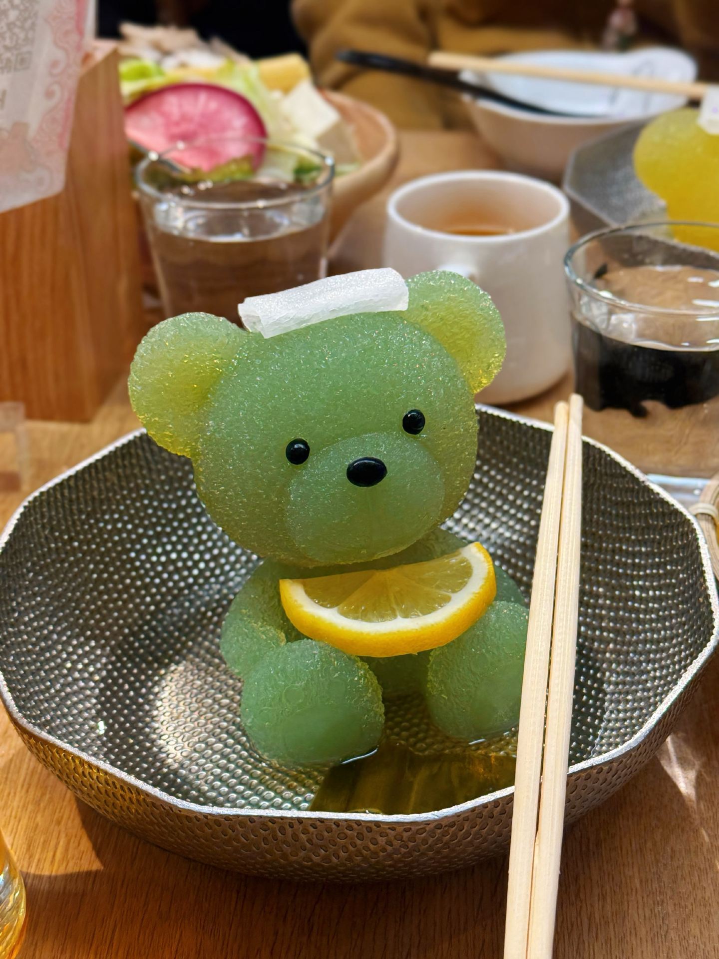 If you’ve ever seen a cute little bear slowly melting into a hotpot on TikTok… this is probably the place. 😂 We visited Kumachan Onsen in Shibuya, and I feel like this restaurant is quite well-known among Singaporeans too. I’d seen it online before, so since we were already in Tokyo, obviously we had to give it a try!

The whole concept is honestly adorable. Kumachan Onsen (くまちゃん温泉) literally revolves around a little bear enjoying an onsen, except unfortunately for Kumachan… the onsen eventually becomes our dinner. 😭😂 The bear is actually made from a soup base that melts as the pot heats up, turning into the broth for your shabu-shabu. The restaurant was originally born in Hokkaido, and the official story is about an onsen-loving Kumachan who travels around before eventually creating his own hot spring in Hokkaido. 

What I liked was that they actually make it into a whole experience rather than just putting the bear on your table and leaving. They tell you the story behind Kumachan, and they even give you bear ears to wear while eating. 😂 Of course I wore them — if I’m already here eating a teddy bear hotpot, might as well fully commit to the theme. The bear ears are actually part of the restaurant’s immersive experience too. 

Then came the star of the meal. 🐻♨️ We had different coloured bears and LOOK AT THEM. How are you supposed to immediately turn on the heat when something this cute is staring back at you?! 😭 Naturally, we spent quite some time taking photos first. Eventually though… sorry Kumachan, into the hotpot you go. 😂 Watching the bear slowly melt was simultaneously cute, satisfying and slightly traumatising.

The meal comes with meat, vegetables and other ingredients for shabu-shabu, and you can choose from different meats and soup flavours. Current prices vary depending on what you order, but I’d roughly budget around ¥3,000–¥4,000 per person for the experience. 

And if you’re going for dinner, another cute part from my visit was that at around 8PM, the Kumachan mascot came out! 🐻😂 So suddenly there was a giant bear walking around after we had just spent dinner watching a smaller version of him melt in our hotpot… slightly awkward HAHAHA. I’d check with the restaurant if you specifically want to catch the mascot though, as appearances may change.

Food-wise, I wouldn’t say I came here expecting the best shabu-shabu of my life. For me, this is somewhere you come for the whole experience — the bear-shaped hotpot, the story, the bear ears, the photos, the themed restaurant and, if you’re lucky, meeting Kumachan himself. 😂

📍 Kumachan Onsen, Shibuya
32-12 Udagawacho, Assorti Shibuya 3F, Tokyo. The official site currently lists the Shibuya main store at this address. 

Would I recommend it? Yes, especially if you love cute and slightly gimmicky dining experiences like me. 😂 Just remember to take ALL your photos before turning on the heat, because once Kumachan starts melting… there’s no going back. 😭🐻♨️

#KumachanOnsen #Shibuya #TokyoFood #TokyoTravel #JapanTravel