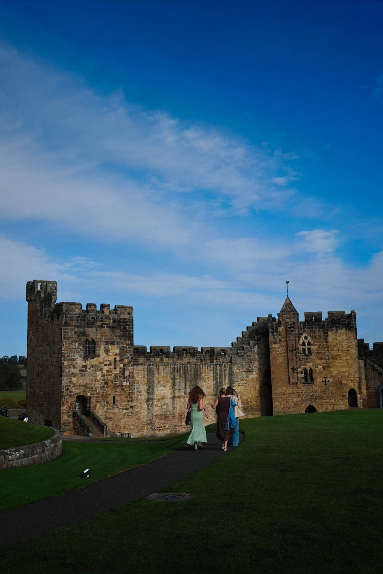 For someone who grew up on Harry Potter (and still spends too much time on fantasy anime and games), visiting the real-life Hogwarts exterior was high on my list for this UK trip. I finally made it to Alnwick Castle in Northumberland, and it did not disappoint.

First, a bit of practical info on getting there, as it requires some planning. I took the LNER train from London King's Cross to Alnmouth station, which took about 3.5 hours. From Alnmouth, you have to catch the X18 bus or grab a local taxi to Alnwick town. If you’re planning a visit, I highly recommend checking the bus schedules beforehand because they don't run very frequently, and missing one can throw off your whole day.

Weather-wise, Northumberland is incredibly windy. Even in the afternoon with some sun, the wind coming off the coast was freezing—definitely pack a proper windbreaker. Since I visited on a weekday, the crowds were quite manageable, though there were still quite a few school groups around.

As someone who works in curation, I found the castle itself fascinating. It’s the second-largest inhabited castle in England, and the Percy family has lived here for over 700 years. The contrast between the ancient Norman military architecture and the lived-in, lavishly decorated state rooms is incredible. 

But the highlight for any fan is definitely the Outer Bailey—the massive lawn where Harry had his first broomstick flying lesson in the Philosopher’s Stone. They actually run "Broomstick Training" sessions on the exact spot. It’s mostly geared towards kids, but the staff are incredibly enthusiastic, and it's quite fun to just stand there and watch everyone trying to yell "Up!" to their brooms. It really felt like stepping right into the film. 

If you love the films or just appreciate medieval history, it’s absolutely worth the long transit. Just remember to dress warmly and book your castle tickets online in advance to save some hassle.