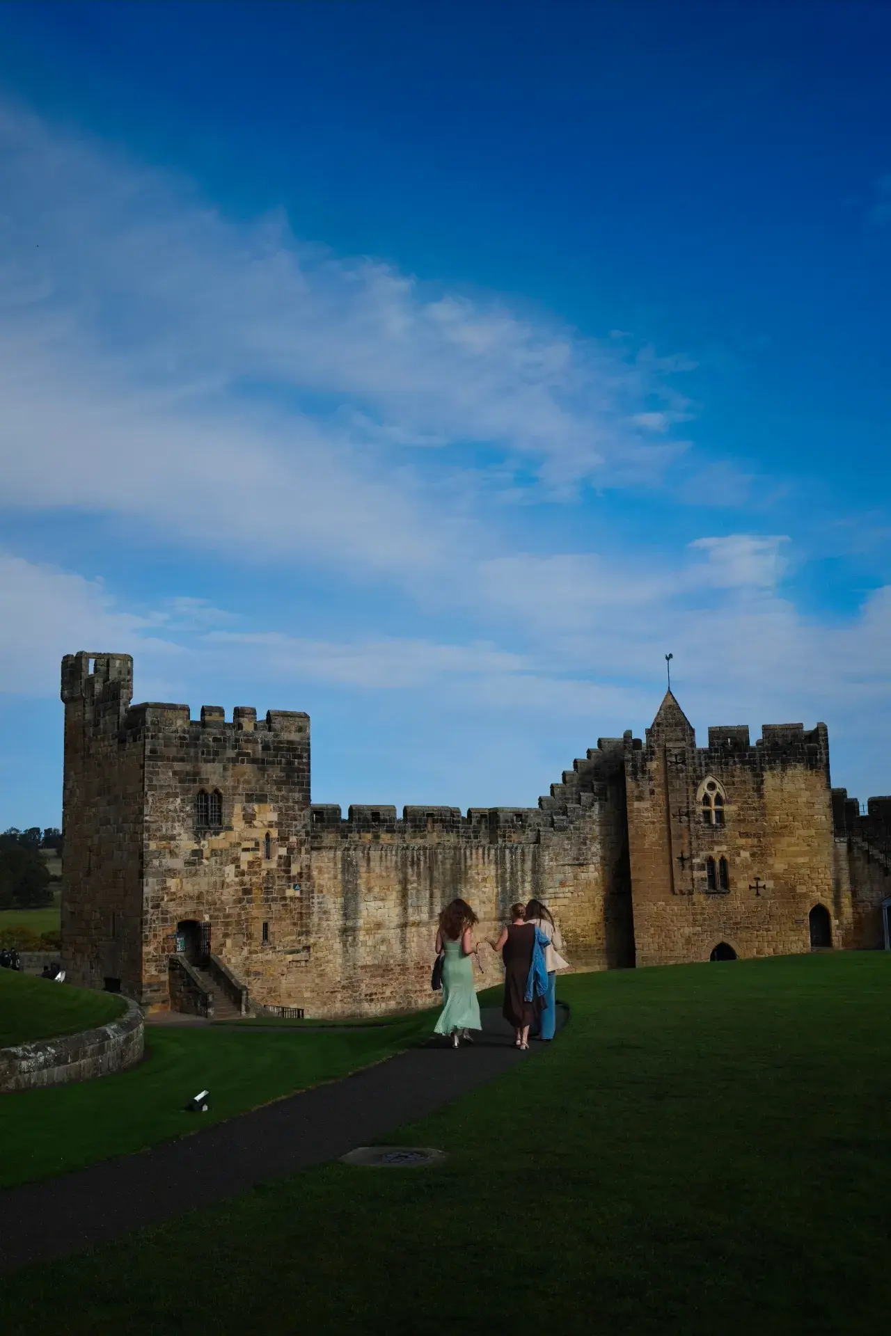 For someone who grew up on Harry Potter (and still spends too much time on fantasy anime and games), visiting the real-life Hogwarts exterior was high on my list for this UK trip. I finally made it to Alnwick Castle in Northumberland, and it did not disappoint.

First, a bit of practical info on getting there, as it requires some planning. I took the LNER train from London King's Cross to Alnmouth station, which took about 3.5 hours. From Alnmouth, you have to catch the X18 bus or grab a local taxi to Alnwick town. If you’re planning a visit, I highly recommend checking the bus schedules beforehand because they don't run very frequently, and missing one can throw off your whole day.

Weather-wise, Northumberland is incredibly windy. Even in the afternoon with some sun, the wind coming off the coast was freezing—definitely pack a proper windbreaker. Since I visited on a weekday, the crowds were quite manageable, though there were still quite a few school groups around.

As someone who works in curation, I found the castle itself fascinating. It’s the second-largest inhabited castle in England, and the Percy family has lived here for over 700 years. The contrast between the ancient Norman military architecture and the lived-in, lavishly decorated state rooms is incredible. 

But the highlight for any fan is definitely the Outer Bailey—the massive lawn where Harry had his first broomstick flying lesson in the Philosopher’s Stone. They actually run "Broomstick Training" sessions on the exact spot. It’s mostly geared towards kids, but the staff are incredibly enthusiastic, and it's quite fun to just stand there and watch everyone trying to yell "Up!" to their brooms. It really felt like stepping right into the film. 

If you love the films or just appreciate medieval history, it’s absolutely worth the long transit. Just remember to dress warmly and book your castle tickets online in advance to save some hassle.