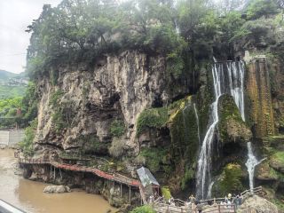 A curtain of spring water falls, gracing a thousand mountains; a winding river flows through, empowering ten thousand ravines.