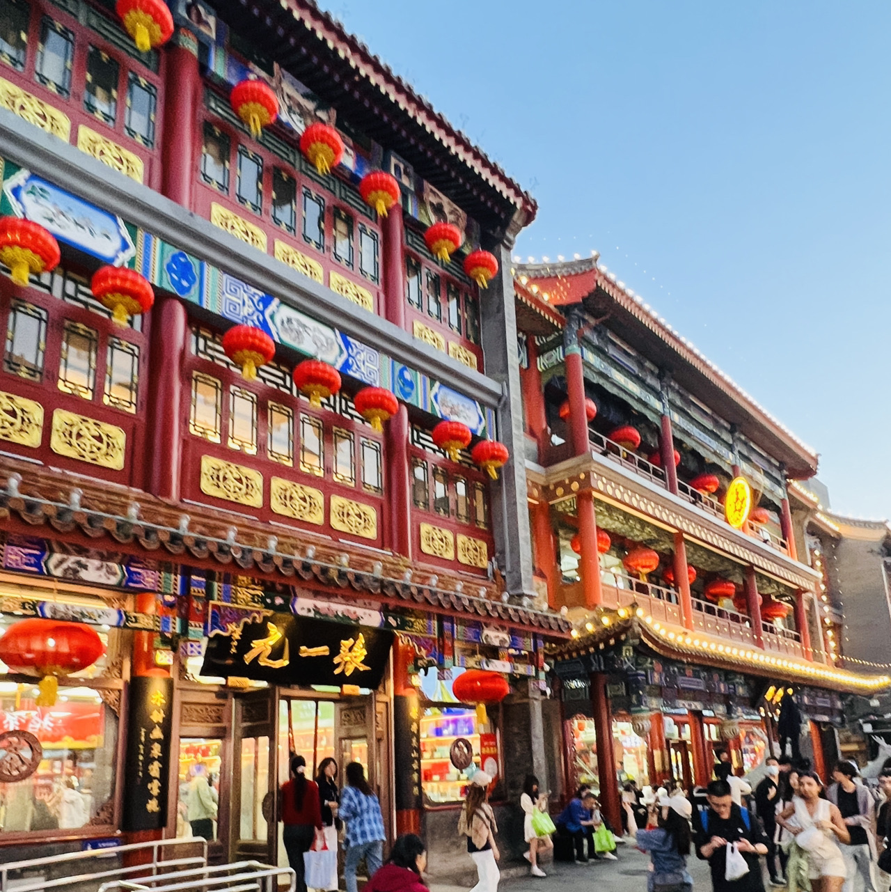 🛺 Qianmen: A "Time Machine" to Old Beijing

This is the main pedestrian artery—an 840-meter stretch boasting 600 years of history—starting from the majestic Zhengyangmen Gate and heading south toward the Temple of Heaven. Its main highlight is the vintage "Dangdangche" (当当车) tram:

· A "Ding-ding" to the past: The tram cars are named after the melodic ringing of the bell the conductor uses to warn pedestrians. It’s this exact sound that creates the authentic atmosphere of old Beijing.
· Like a time machine: Two trams run along a single track from north to south and back. The ride takes about 10 minutes, with departures every 35-45 minutes.
· "Living set" effect: Before departure, a conductor in a vintage uniform clears the crowd off the tracks—a highly picturesque sight that adds a touch of theatricality.

🏛️ Architecture and Vibe

The street is lined with buildings in a unique "Chinese Baroque" (中西合璧) style, blending Chinese and European motifs from the early 20th century. Tucked behind the main facade is Dashilan Alley, where history feels even more palpable. Here, you can find traditional Chinese tea and silk shops, and grab a tanghulu (candied hawthorn on a stick).

🍜 Shopping and Dining

· Where to visit: The legendary Quanjude (全聚德) restaurant, which first served Peking duck in 1864; the Tongrentang (同仁堂) pharmacy (founded in 1669); and the Ruifuxiang (瑞蚨祥) store, a former silk supplier for the imperial court.
· What to eat: Besides the duck, you absolutely must try the traditional Beijing snacks and street food sold everywhere. At the end of your stroll, pop into the traditional Chinese-style Starbucks for a quick break.

🌙 Best Time to Visit

The ideal time to visit is after 6:00 PM. The evening illuminations make the street look especially festive, the tram looks stunning against the glowing lights, and the daytime heat fades away. Entrance to the street itself is free and open late.
Tram tickets cost 20 yuan for a one-way trip.

🚇 How to Get There

The most convenient way is by subway: take Line 2 or 8 to Qianmen Station.