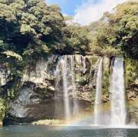 "Cheonjiyeon Waterfall: A Stunning View with a Rainbow on Jeju Island"