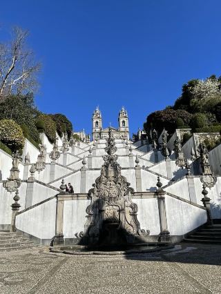 Bom Jesus do Monte 🇵🇹 Beautiful from the first step to the top.

Another place in Portugal that we really loved is Bom Jesus do Monte in Braga. The most striking feature is the large white stone staircase leading up in layers, lined with fountains, statues, and beautiful details along the way.

Upon our first arrival, we felt that the actual place was even more magnificent than the pictures. The staircase is stunning and has a unique dimension, especially when viewed from the bottom, perfectly aligned to reach the church at the top.

The day we went, the sky was clear and sunny. The blue sky contrasted beautifully with the white staircase and the green trees, making everything look vibrant. The climb was a little tiring, but there were many places to rest and take photos along the way, so we didn't feel rushed.

Once we reached the top, the view was worth it. The atmosphere was more peaceful than at the bottom. There was the church itself, a large plaza, and a panoramic view of the city in the distance. It was one of the best moments of our trip.

If you're visiting Braga, we recommend allocating some time to Bom Jesus do Monte. Don't just come to take pictures with the staircase and leave. Because the details along the way are just as beautiful.

📍 Bom Jesus do Monte, Braga, Portugal 🇵🇹
For us, it's another place that's beautiful, unique, and almost every angle is perfect for photos. 🤍✨