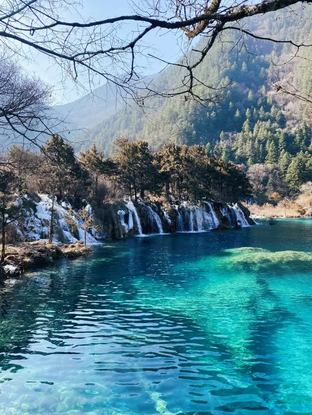 Why is it recommended to travel to Jiuzhaigou in winter (January-February)?