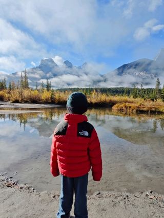 Three Sisters Viewpoint is Canmore's most famous photo spot, renowned for its postcard-perfect views of the Three Sisters peaks reflected in the calm waters of the stream.
To get there, pin "Canmore Off-Leash Dog Park" on Google Maps to your GPS and park in the free gravel parking lot located on the Bow Valley Trail.
Finding the Underpass: Walk out of the parking lot onto the highway and look for the large concrete underpass/bridge that spans beneath the road and railroad tracks. Following the Trail: Walk through the underpass. Once on the other side, you'll cross the dry, rocky Cougar Creek. Follow the barely visible but clearly marked footpath into the woods towards the Bow River and the Swamp: Within about 5 minutes, the trail opens up to a small, tranquil swamp fed by Policeman's Creek, where you'll find the unique reflection view. This trail is also inhabited by wildlife; you may encounter animals along the way. During our visit, we saw a deer. Try to keep your distance and avoid getting too close. #treesistersview #canmore