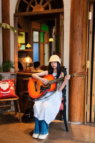 A century-old paulownia wood house meets vintage French romance. A girl in a white dress freezes her sparkling youth here. The window view of the vintage café and blooming flowers