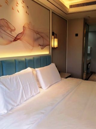 🏨Chapter 1|Tai'an Ximei Retreat Hotel

Choose Ximei Retreat Hotel for your Mount Tai hike and enjoy a tranquil retreat at the foot of the mountain. The room design incorporates the essence of nature, with ink-wash mountain landscape murals above the bed paired with warm lighting, and a simple yet elegant blue upholstered headboard. After your climb, return to your room, lean against the soft bedding, and let the fatigue of your journey slowly dissipate, allowing you to quietly enjoy a relaxing moment.✨

The room's tea station is fully equipped, with a kettle, drinking water, and teacups neatly arranged, and a small refrigerator underneath. Store drinks and fruit before your hike, and enjoy refreshing water upon your return.🧊 These small details are thoughtfully designed for hikers, making your stay more convenient and worry-free.

The bathroom area is clean and refreshing, with a bright and tidy marble countertop and high-quality toiletries. The washroom is logically laid out, with separate wet and dry areas, perfect for relaxing after a day of hiking. A clean and comfortable environment ensures hygiene for guests, providing a sense of peace of mind during your trip. 🚿

Elegant greenery and decorative items adorn various parts of the hotel, with celadon vases paired with fresh greenery and dried flowers, creating a simple yet sophisticated oriental ambiance. 🪴 Soft lighting casts shadows on the objects, creating a tranquil and soothing atmosphere. Wandering through the hotel space, you'll find exquisite soft furnishings everywhere, immersing you in the refined aesthetics at the foot of Mount Tai.

The overall space features a light luxury black and gold style, with golden starlight accents enhancing the ambiance. 🌟 From the guest room furnishings to the small decorative items in the corners, the design is unified and harmonious, without unnecessary embellishments. Whether you're hiking with friends or traveling with family, you can enjoy a high-end and warm stay. 💫

The hotel is situated at the foot of Mount Tai, boasting a superior location and convenient access for hiking. The guest rooms are well-equipped with thoughtful and practical amenities, balancing comfort and functionality. After concluding your ascent of Mount Tai, return to this warm and inviting accommodation, ensuring a comfortable and unforgettable stay throughout your Mount Tai journey. 🏡

🚶Chapter Two|A Stroll Through the Old Town of Tai'an

After climbing the majestic Mount Tai, be sure to explore the streets and alleys of Tai'an's old town and experience the authentic, everyday life of the city. 🏮 Rows of old shops, weathered wooden doors, and retro signs reveal the city's most rustic charm. Wander leisurely through the streets, shedding the fatigue of the climb, and feel the simple, warm daily life of the locals.

The old streets and shops hold the dedication of artisans. From shoe repair and leather craftsmanship to the hammering of hammers and the weaving of needles, each piece is imbued with the warmth of time. Stop and observe, feel the charm of traditional craftsmanship, and experience the dedication of generations of artisans in the old town.

Street stalls are filled with dried goods and local specialties. The vendors quietly tend to their wares, exuding a vibrant sense of everyday life. Simple plastic baskets and old-fashioned boxes—no fancy packaging, just authentic local produce. Choose your local specialties here and take home a taste of the unique flavors of Tai'an's old town.

Retro-style small grocery stores retain their old-fashioned wooden windows. An elderly woman tends her shop, while children tiptoe to buy snacks. Warm light fills the wooden lattice windows, as if transporting you back to bygone days. Each window tells a story; these nostalgic shops are hidden gems in the old town, offering a sense of healing.

Hidden in the alleys are traditional folk handicrafts. Brightly colored red cloth horse pendants with exquisite embroidery patterns—the rich folk customs of Dongyue make meaningful souvenirs. Bring home a small folk souvenir, carrying with you the blessings of peace and the memories of the old town of Tai'an.

Everywhere you look, you'll see the everyday life of the people: a bicycle repairman carefully inspecting a bike, vendors quietly waiting for customers. Sunlight filters through the streets, casting long and short shadows on the walls—simple scenes that soothe the soul. Every corner tells a story of the old town's leisurely and carefree life.

Mount Tai boasts magnificent mountains and rivers, while the old town holds the warmth of everyday life. Climb to the summit to feel the grandeur of the mountains, and encounter the tenderness of the streets. The majestic mountains and vibrant streets complement each other; only by experiencing both can you fully understand the unique romance and profound history of Tai'an.

#Tai'anTourism #DaiTemple #MountTaiScenicArea-Hongmen #Tianwaicun #Tai'anXimeiHiddenRetreatHotel