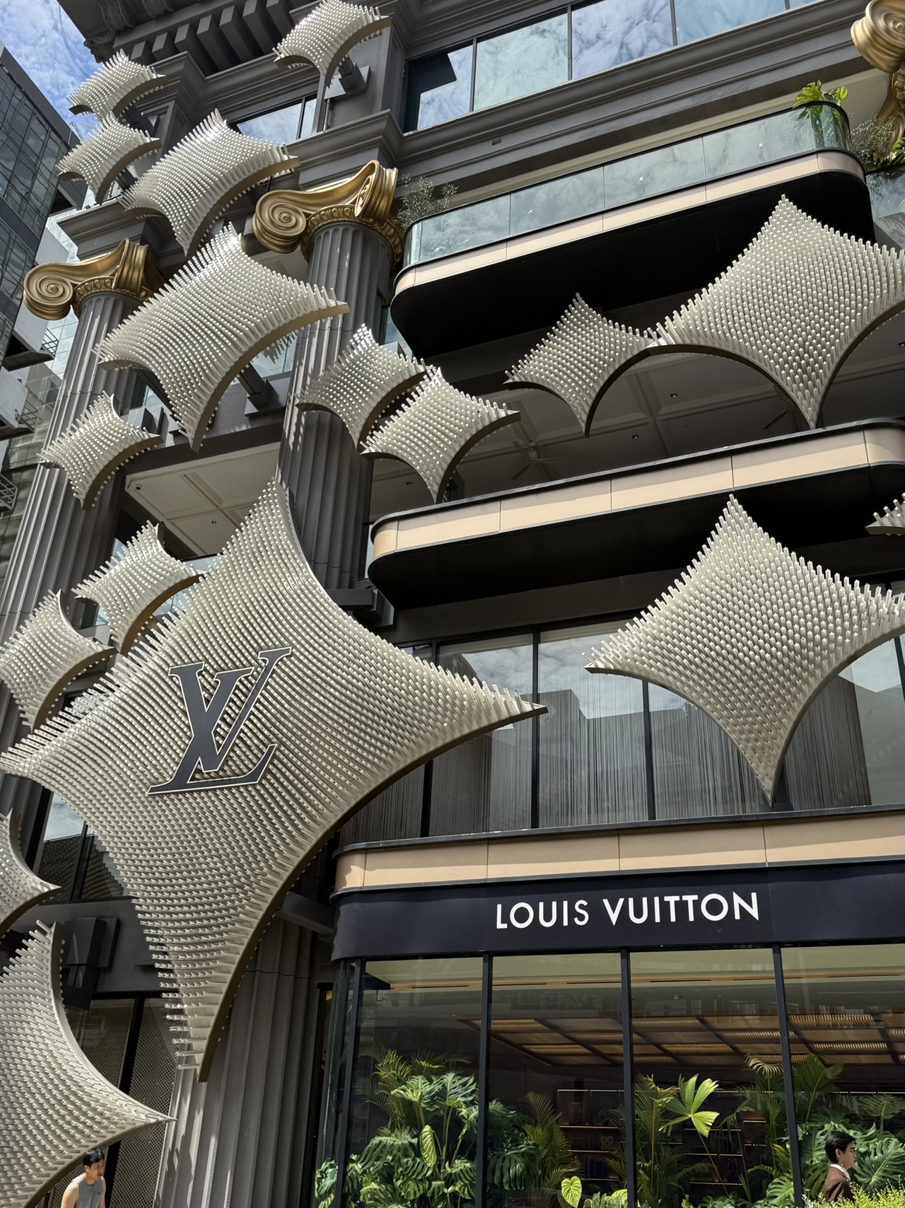 🧳 Sebuah pameran imersif bertajuk Visionary Journeys kini telah dibuka di Bangkok.

⭐️ Apa yang bisa ditemukan di dalam pameran:
The Trunkscape Tunnel. Pameran ini menyambut tamu dengan koridor luar biasa yang terbuat dari 96 koper (trunk) vintage Louis Vuitton yang ikonik. Dinding dan langit-langitnya dilengkapi dengan layar dinamis yang berubah warna dan menciptakan kesan gerakan. Lokasi ini sangat populer untuk syuting reels, jadi pastikan kamu mengabadikan momen saat sedang sepi pengunjung.
⭐️ The Origins Room dan Archive Icons. Kamu akan berjalan melalui aula yang menampilkan dokumen sejarah langka, koper perjalanan pertama (termasuk koper tempat tidur lipat yang menakjubkan), dan 21 tas ikonik dari 25 tahun terakhir. Model karya Marc Jacobs, Virgil Abloh, dan Pharrell Williams melayang di dalam bola akrilik transparan — tampilannya sangat memukau.
⭐️ The Collaborations Hall dan Interactive Finale. Area terpisah didedikasikan untuk kemitraan profil tinggi merek tersebut dengan para seniman (Yayoi Kusama, Takashi Murakami, Supreme). Di bagian paling akhir, di ruangan cermin yang terinspirasi oleh lampu-lampu pasar malam Bangkok, kamu akan menemukan mesin interaktif tempat kamu bisa memenangkan suvenir berkesan dari merek tersebut dengan tiketmu (seperti kartu pos atau poster bermerek).
🫶 Tips perencanaan: Masuk ke pameran ini sepenuhnya gratis, tetapi kamu tidak bisa datang begitu saja secara spontan. Kamu harus memesan slot waktu terlebih dahulu di situs web resmi Louis Vuitton.
🔥 Di akhir pameran, ada mesin tempat kamu bisa mendapatkan hadiah gratis dari LV. Bisa berupa kartu pos, pena, poster, atau tas belanja (shopper bag).
Aku beruntung dan mendapatkan shopper bag!!
Staf bilang itu hadiah yang sangat langka.

Cara menuju ke sana: Pusat perbelanjaan Gaysorn Amarin terletak tepat di pusat kota. Cara termudah adalah naik BTS Skytrain ke stasiun Chit Lom, yang memiliki jalur pejalan kaki tertutup langsung menuju gedung tersebut.
   art travel