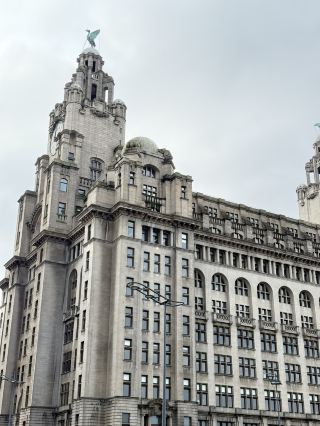 Royal Liver Building is one of Liverpool’s most iconic waterfront landmarks, completed in 1911 and famous for its grand clock towers and the legendary Liver Bird statues perched on top. Located at Pier Head, it forms part of the historic “Three Graces” and offers visitors guided tours and a panoramic viewing platform with stunning views over the River Mersey and Liverpool skyline.