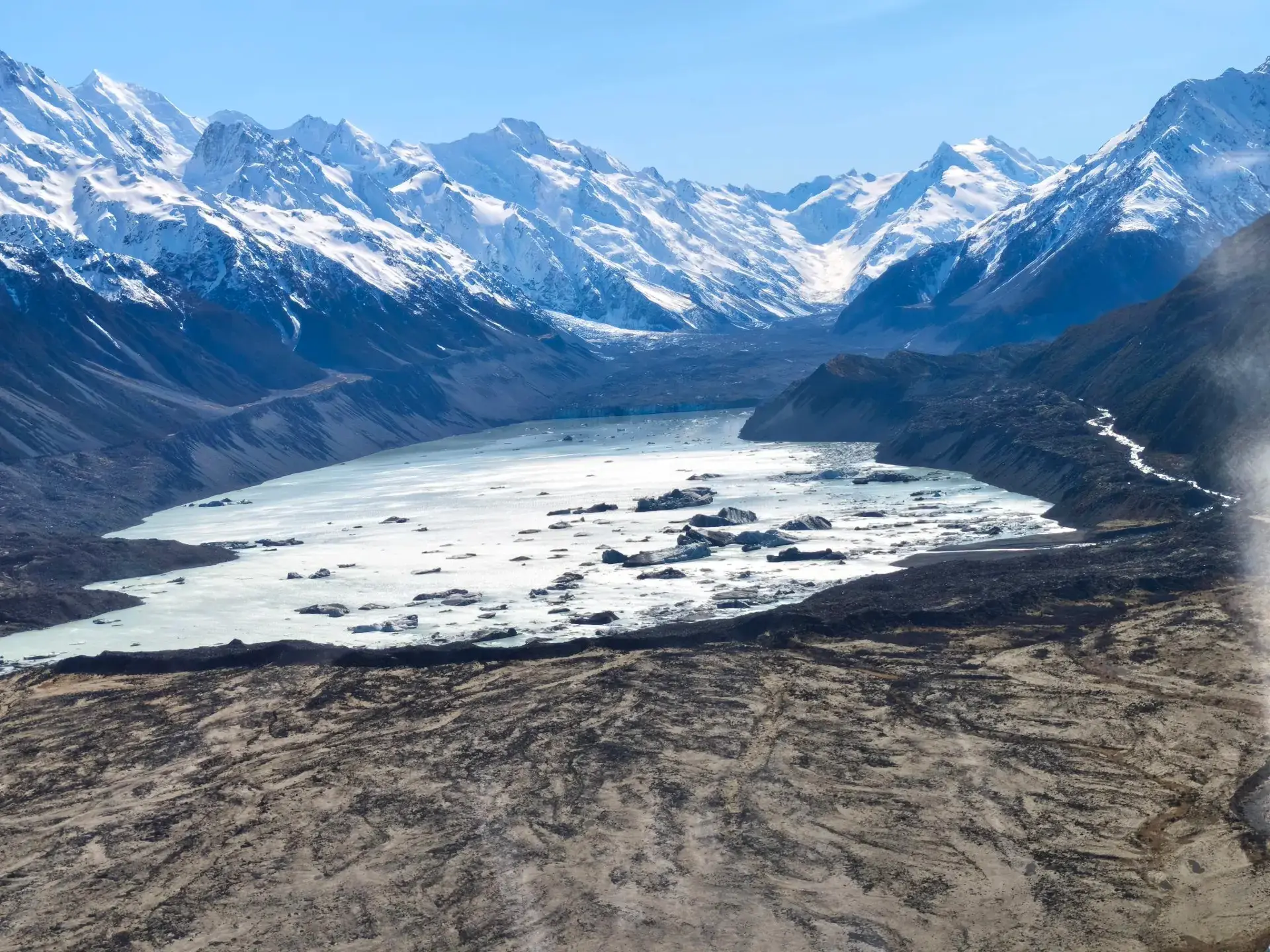 The Mount Cook heli-hike is an unforgettable adventure that combines a thrilling helicopter ride with a guided walk on New Zealand's largest ice mass, the Tasman Glacier. The journey starts with a helicopter flight over Aoraki/Mount Cook National Park. We arrived about 40 minutes earlier as we were advised to reach at least 30 minutes earlier. Before boarding, we were briefed with important information and changed the shoes provided. From the sky, we can see giant snow-covered mountains. Once we landed, we put on special spikes called crampons on our boots so we do not slip. Our guide Tori led us across the ice to explore the frozen landscape filled with blue cave and icy pathways. She is friendly and nice, took some wonderful photos for us. After spending about 1.5 hours exploring, the helicopter picked us up and flew us safely back to the base, leaving us with memories of an incredible alpine world.