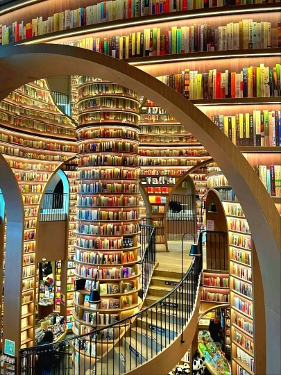 #chinaadventures

Stepping into Zhongshuge Bookstore in Chengdu feels like entering a dream sculpted from books, light, and imagination. As a photographer, I’m immediately drawn to the dramatic curves and mirrored surfaces that stretch shelves into infinity. The space plays with perception—arches melt into reflections, staircases appear to float, and books become architectural elements rather than objects. Every angle challenges the lens, inviting experimentation with symmetry, depth, and illusion.

Light is the silent storyteller here. Soft, ambient glows highlight the warm tones of wood and paper, while reflections multiply scenes into surreal compositions. Shooting low exaggerates the towering shelves, while wide angles capture the cinematic scale of the space. Even the quiet presence of readers adds life, their silhouettes grounding the fantasy with a human touch. Close-ups reveal textures—the grain of timber, the spines of books, the subtle interplay of shadow—while long shots transform the bookstore into a modern cathedral of knowledge.

Photographing Zhongshuge Chengdu is about more than documenting a bookstore; it’s about capturing a visual narrative where literature meets art and architecture. Each frame feels like a portal, a moment where reality bends and stories come alive—not just on the page, but through the lens itself.