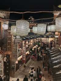 Wangxian Valley: Night Market Lights Reflecting Visitors