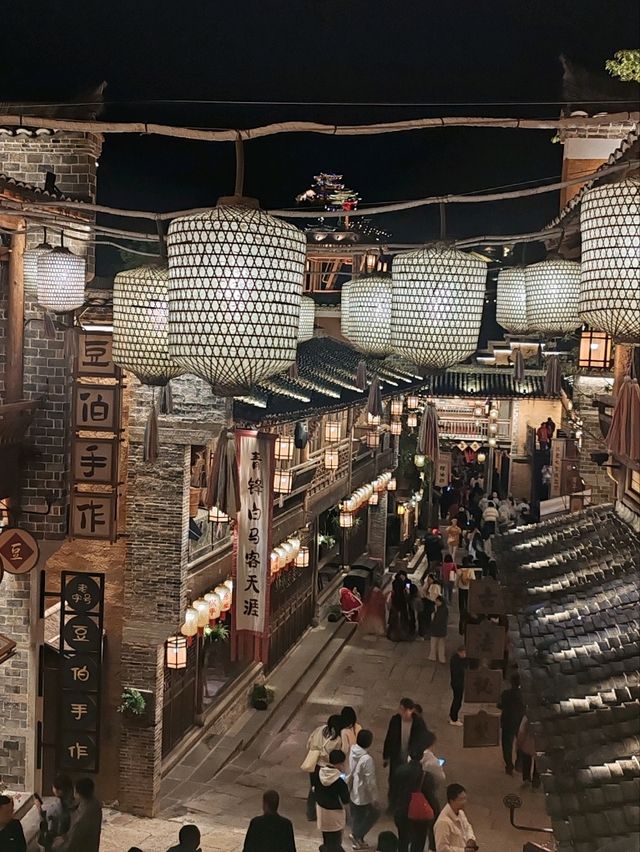 Wangxian Valley: Night Market Lights Reflecting Visitors