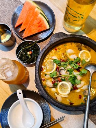 城の中にある雲南・貴州料理の居酒屋！赤ワイングラスで提供される冷麺、漬け魚の横にはバラの花🌹
