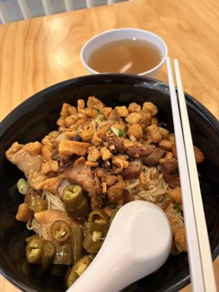 #springflower 

It was sheer hunger that pulled me into Soi 19 Thai Wan Tan Mee at Bugis that day—I’d barely glanced at the sign before the words “authentic Thai street food” had me pushing the door open. Once seated, I went straight for the Thai-style wanton mee, but with a crucial tweak: extra pork lard, please. When the bowl landed, steam curling upward, I knew I was in for something special. The noodles were bouncy and slick with a dark, fragrant sauce, mingling with slices of honeyed char siu, leafy choy sum, and soft, skin-wrapped wontons. But the pork lard—those tiny, crackling golden jewels—stole the show. Each piece shattered between my teeth, releasing a warm, salty, fatty essence that clung to every noodle and made each mouthful feel like a secret Bangkok alleyway on a plate. I ate slowly at first, savouring, then quickly, greedily, until only the light, peppery broth remained. That bowl didn't just fill me up—it left me grinning, completely and utterly satisfied.