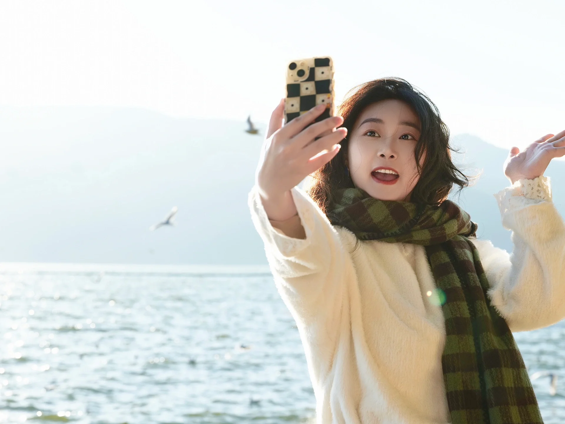 📷 Haihong Wetland Park is an excellent spot for photographing seagulls in Kunming.
⏰ Best time: For avoiding crowds, choose 8:30-9:30 AM when there are fewer people and the lighting is good. If you want to capture the effect of seagulls flying all over the sky, go between 4:30-6:00 PM, where you can also photograph the beautiful scene of seagulls flying with the Dianchi Lake sunset in the background.
📍 Photo spots: Enter from the northeast gate, walk straight towards Dianchi Lake to see the seagull flock. You can also enter from the north gate, walk to the flower bed by Dianchi Lake, then turn left; near the viewing platform about 100 meters in front of and behind the small white bridge, there are more seagulls.
📷 Photography tips: For equipment, use burst mode on your phone; for cameras, a 70-200mm telephoto lens is recommended. For composition, shoot the flock of seagulls from a low angle looking up, or capture silhouettes with backlighting.
🍂 Outfit and props: Wearing light or bright colors makes your photos stand out. You can prepare props like fresh flowers, scarves, hats, and a transparent umbrella which can protect you from wind and seagull droppings.
‼️ Notes: Kunming has a big temperature difference between morning and evening in winter, and it’s windy by Dianchi Lake in the afternoon. Remember to bring a thick coat and be careful while taking photos.