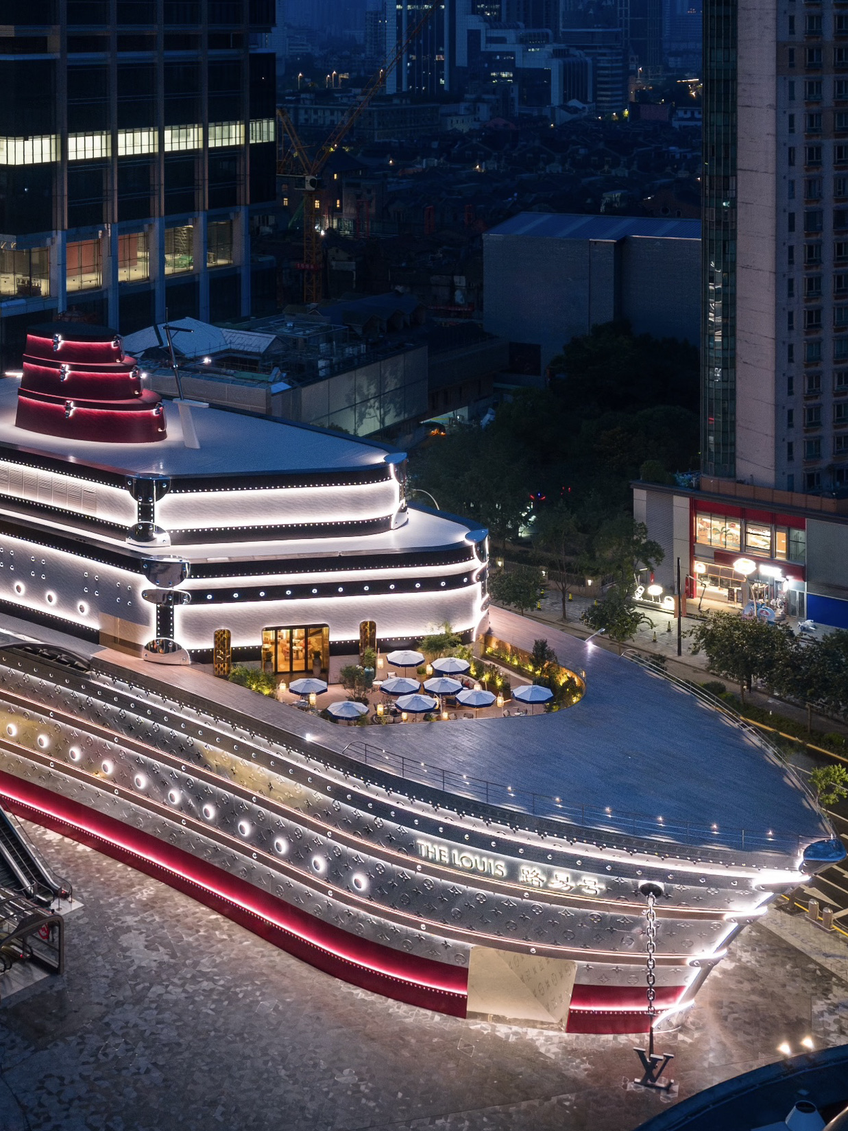 💎 Apaan tuh? 
Bangunan berbentuk kapal raksasa sepanjang 30 meter yang full tertutup monogram ikonik LV. Di dalamnya — ada pameran gratis, butik, dan pastinya, Le Café Louis Vuitton.
📍 Lokasi: 789 West Nanjing Road (seberang Starbucks Reserve)

☕ Pesan apa ya?

· Latte dengan latte art bentuk kelinci 🐇
· Wafel MONOGRAM
· Kue-kue musiman racikan head pastry chef mereka

💰 Harga: minuman ~ mulai $8 (58 RMB), dessert ~ mulai $9 (68 RMB) 

🎫 Cara masuknya gimana?
Masuknya gratis, tapi kamu wajib reservasi via WeChat (mini-program My LV). Kafenya juga butuh reservasi terpisah. Wajib rencanain dari jauh hari — slotnya cepet banget ludes!

💡 Life hacks & Tips

· Waktu terbaik: sore hari buat foto-foto, dan setelah sunset lampu cantiknya nyala, bikin "kapal" ini kelihatan makin wow
· Posisi duduk pewe: di teras outdoor - view terbaik ke Nanjing Street
· Spot foto: seluruh areanya Instagrammable banget - mulai dari lorong sejarah brand sampai dek kapal dengan monogram
· Pembayaran: Terima WeChat Pay, Alipay, dan kartu internasional
· Kalau ribet reservasi: tenang, ada meja staf di dekat pintu masuk yang siap bantuin kamu daftar

Ini bukan cuma sekadar kafe biasa. Ini tiket kamu buat ngerasain dunia luxury, ditemani secangkir kopi. Jenius, cantik, dan Shanghai banget ✨