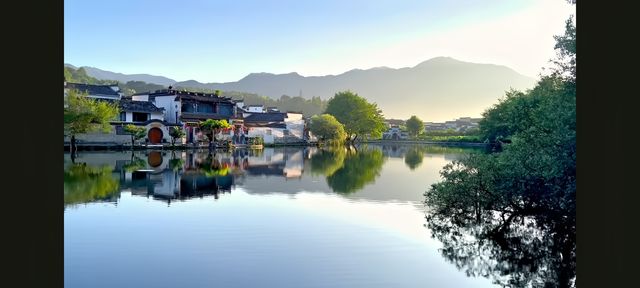 墨痕深處覓徽州  

踩著晨霧未散嘅青石板，我跌入咗徽州嘅水墨長卷裡。呢度嘅山、水、村落，都似係從硯台