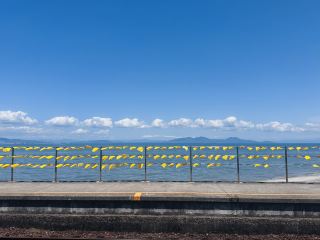 黄色い列車と真っ青な海が織りなす絶景—島原鉄道「大三東駅」。