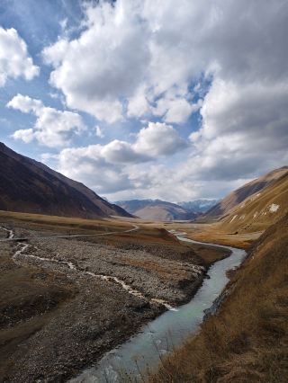 A bubbling mineral lake and breathtaking views in the Georgian mountains in autumn. Truso Valley