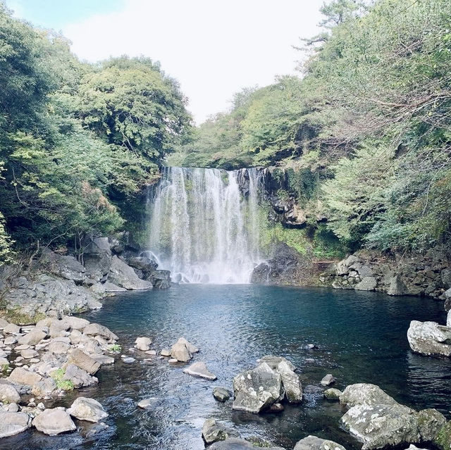 "Cheonjiyeon Waterfall: A Stunning View with a Rainbow on Jeju Island"
