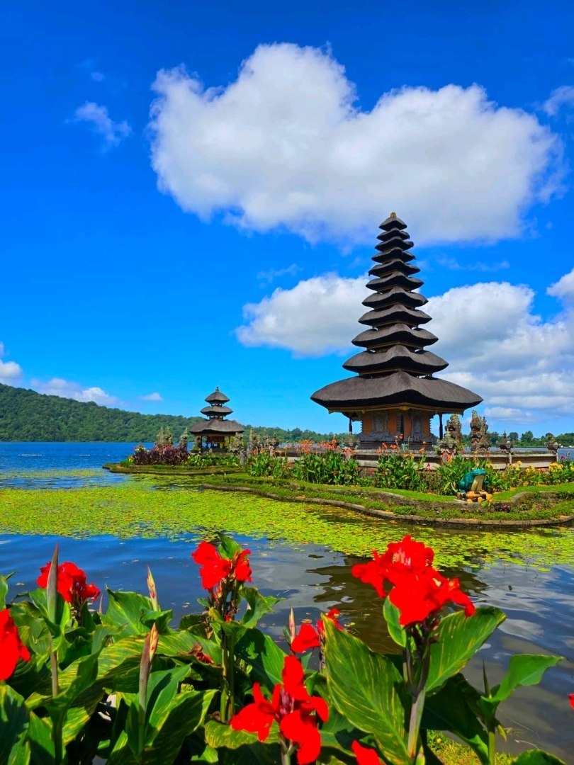 Pura Air di Ubud, Bali, yang juga dikenal sebagai Pura Ulun Danu Bratan, terletak di tepi Danau Bratan di Bali utara. Dibangun pada tahun 1633, pura ini menggabungkan gaya arsitektur Hindu dan Buddha serta merupakan situs religius yang sakral bagi masyarakat setempat 🙏🏻. Arsitektur pura yang elegan dikelilingi oleh pemandangan danau dan pegunungan, dengan angin pegunungan dan pantulan cahaya yang berubah-ubah di danau, menciptakan suasana yang mempesona. Penampilannya yang unik menjadikannya salah satu daya tarik ikonik Bali, menarik banyak pengunjung.

Bagi wisatawan, pura beratap jerami bertingkat gaya Hindu yang berdiri di danau adalah spot foto utama 📸. Pura-pura ini memiliki struktur persegi dengan beberapa atap jerami bergaya pagoda di atas dasar bata, ciri khas Bali. Pura, danau, dan pegunungan yang jauh saling memantulkan, membentuk lukisan pemandangan yang indah. Gerbang masuk pura yang melambangkan kebaikan dan kejahatan juga memiliki karakteristik Bali dan menjadi spot foto yang populer.

Kali ini, kami menggunakan mobil pribadi dari Nusa Dua bagian selatan menuju Pura Air, yang memakan waktu sekitar dua jam. Setelah itu, kami juga mengunjungi Gerbang Bali Handara dan Istana Ubud yang berada di dekatnya. Namun, perjalanan pulang sangat macet, memakan waktu tiga jam untuk kembali ke Nusa Dua.