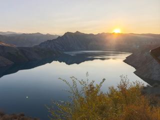 🌿【เคนสวัต: อัญมณีเร้นลับที่แกะสลักจากหิมะละลายเทียนซาน】

—78 กิโลเมตรทางตะวันตกเฉียงใต้ของอำเภอมานัส | สุดยอดอัญมณีเฉพาะทางในซินเจียงตอนเหนือ | ไม่ใช่จุดชมวิว แต่เป็นภาพร่างผืนแผ่นดินที่ยังไม่ถูกเปิดเผย

⚠️ สิ่งสำคัญที่ต้องเตรียม:

🔹 เคนสวัต | เป็นหน่วยภูมิศาสตร์อิสระ: หุบเขาแม่น้ำเคนสวัต + อ่างเก็บน้ำเคนสวัต + ทุ่งหญ้าบริสุทธิ์

🌄【ความจริงทางภูมิศาสตร์: เข้าใจก่อน】

📍พิกัด: 86°12′E, 44°28′N | ระดับความสูง: 1,350 เมตร (พื้นหุบเขา) – 2,860 เมตร (ปากเขื่อน)

💧เส้นชีวิต: แม่น้ำเคนสวัต (สาขาที่ใหญ่ที่สุดของแม่น้ำมานัส) มีต้นกำเนิดจากธารน้ำแข็งยอดเขาโบกดา ซึ่งเป็นยอดเขาหลักของเทือกเขาเทียนซาน

⛰️ ลักษณะภูมิประเทศ 3 แบบ:

① หุบเขาธารน้ำแข็งรูปตัว U (เกิดจากการกัดเซาะของธารน้ำแข็งเมื่อหลายหมื่นปีก่อน กว้าง 800–1,500 เมตร มีหน้าผาสูงชันอยู่สองข้างทาง)

② ร่องน้ำที่เชื่อมต่อกัน (น้ำในแม่น้ำที่ไหลบ่าก่อตัวเป็นสายโซ่สีเงินหลายสิบสาย เผยให้เห็นชายหาดกรวดในช่วงฤดูแล้ง และกลายเป็นพื้นผิวที่เหมือนกระจกในช่วงฤดูฝน)

③ ธรณีสัณฐานตันเซียชั้นหินแดง (หินทรายยุคจูราสสิกที่ผุพังจนมีสีแดงออกน้ำตาล เหลืองสนิม และม่วงอมเทา ตัดกับสีฟ้าเย็นตาของยอดเขาที่ปกคลุมด้วยหิมะ)

📌ชาวมานัสเรียกสถานที่แห่งนี้ว่า "จานสีของเทือกเขาเทียนซาน เส้นเลือดของโลก"

｜จากเขตมานัส → ด่านตรวจเคนสวัต (ขับรถ 1 ชั่วโมง 10 นาที)

｜เข้าสู่หุบเขา · [องก์ที่ 1: กระจกแห่งกรวด ชายหาด]

รุ่งอรุณ เมื่อระดับน้ำลดลง ชายหาดจะดูราวกับกระจกขนาดยักษ์ สะท้อนภาพภูเขาหิมะบ็อกดา—

- รายละเอียดพื้นดิน: ก้อนกรวดถูกปกคลุมด้วยริ้วน้ำแข็ง ซึ่งเป็นหลักฐานของลิ้นน้ำแข็งที่เสียดสีกับพื้นผิวมานานนับพันปี

| [องก์ 2: โรงละครรอยพับชั้นแดง]

🌟จุดแวะพัก: ลงจากรถบัสและเดิน 200 เมตรไปยังขอบหน้าผาเพื่อชมวิวมุมสูง:

▪ ภาพระยะใกล้: หินทรายสีแดงอมน้ำตาลในยุคจูราสสิกที่มีรอยพับเป็นคลื่น (ทางธรณีวิทยาเรียกว่า "การเสียรูปของตะกอนอ่อน")

▪ ระดับกลาง: แม่น้ำเคนสวัตคดเคี้ยวราวกับเส้นเงินผ่านพื้นหุบเขาที่พับตัว

▪ มุมมองไกล: ยอดเขาบ็อกดาที่ปกคลุมด้วยหิมะตลอดเวลา เปล่งประกายแวววาวดุจโลหะภายใต้แสงแดดยามเที่ยงวัน

| [องก์ที่ 3: หัวใจแห่งอ่างเก็บน้ำ] (K35 | เขื่อนอ่างเก็บน้ำเคนสวัต) สุดถนนลาดยางยาว 2.8 กม. และยังเป็นจุดสูงสุดในหุบเขา (1,860 ม.)

🌟อย่ามองเขื่อน ให้มอง "ด้านหลัง":
▪ เดินอ้อมไปทางด้านท้ายเขื่อน จะเห็นหิมะละลายไหลทะลักออกมาจากทางน้ำล้น (อุณหภูมิน้ำคงที่ 8-12 องศาเซลเซียส และหมอกที่ลอยขึ้นราวกับลมหายใจมังกร)

▪ เดิน 500 เมตรไปตามทางน้ำล้นเพื่อไปยัง [สระมรกต]: เนื่องจากมีแร่ธาตุจากธารน้ำแข็งเทียนซาน น้ำจึงมีสีเขียวมรกตสวยงามอย่างน่าอัศจรรย์

มองเห็นก้อนกรวดที่ก้นสระได้ชัดเจน แต่เย็นยะเยือกจนแทบแข็งตาย

เมื่อคุณยืนอยู่ริมสระมรกต มองดูหิมะละลายพากาลเวลานับพันปีให้ไหลลงสู่เบื้องล่าง

ในขณะนั้น คุณจะเข้าใจว่า สิ่งที่เรียกว่าความยิ่งใหญ่

นั้นมิใช่อะไรอื่นใด นอกจากมนุษยชาติที่ในที่สุดก็ยอมรับว่าตนเองเป็นเพียงเม็ดทรายที่ถูกพัดพาไปตามสายน้ำ