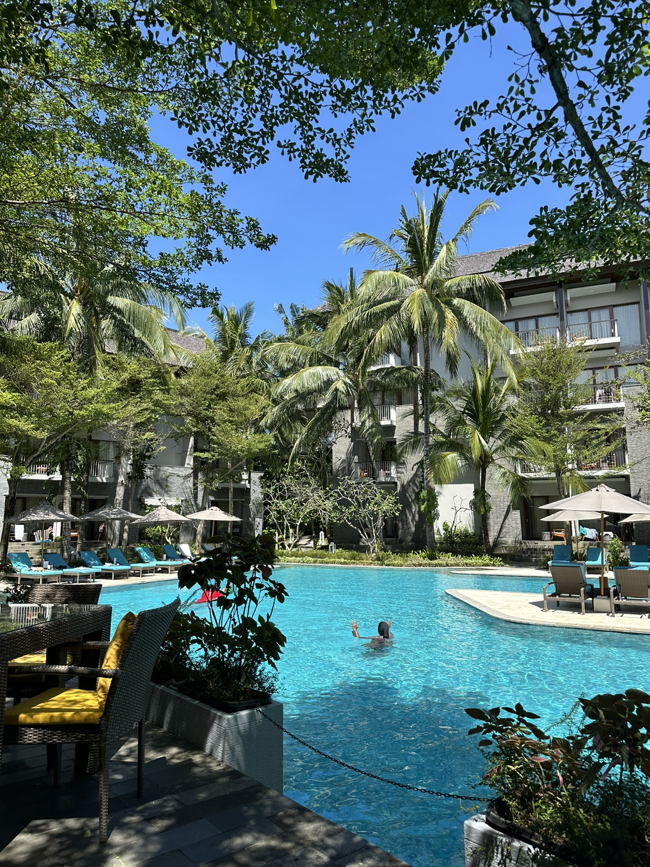 Kali ini, saya terbang ke Bali dan menginap di Courtyard by Marriott di area Nusa Dua, Bukit, Bali.
✈️ Tiba di Bandara Ngurah Rai Bali (satu-satunya bandara di pulau Bali).
🚘 Saya memesan transfer melalui Trip setelah membeli tiket pesawat dan reservasi hotel. Transfernya murah sesuai harga pasar, dan perjalanan dari bandara ke hotel memakan waktu 25 menit di jalan tol (termasuk dalam harga transfer).
☘️ Hotel menyambut saya dengan halaman hijau yang indah dan lobi yang luas dan bergaya dengan seorang musisi yang memainkan melodi Bali yang menyenangkan.
⚓️ Saya langsung diantar ke kamar dengan balkon, sempurna untuk bersantai dengan secangkir teh.
💴 Kemudian saya kembali ke lobi ke kantor penukaran uang untuk menukar mata uang. Nilai tukarnya sama seperti di luar hotel.

☕️ Saatnya makan camilan - saya turun ke restoran hotel yang menghadap kolam renang, makan siang, lalu berenang.
🏊♀️ Kolam renang hotelnya bagus; itu alasan utama saya memilih hotel ini - letaknya di tengah hotel, teduh oleh pepohonan, memiliki area crepes, dan ada banyak ruang untuk berenang. Hanya sedikit orang yang berenang di pagi dan sore hari.
🏖️ Transfer dari hotel ke pantai - ke beach club-nya dengan kursi santai yang nyaman, minuman, dan makanan ringan (dari menu). Pantainya panjang dan luas, salah satu yang terbaik di Bali; Anda bisa berenang lama saat air pasang.
🌊Berjalan kaki ke Waterblow - tempat yang indah dengan batuan vulkanik hanya 5 menit berjalan kaki dari pantai. Ombak yang menghantam bebatuan sangat memukau.
☕️ Sarapan di hotelnya enak. Mereka menyajikan minuman obat tradisional Jamu - jangan sampai ketinggalan. Pilihan hidangan lokal dan India yang beragam, serta hidangan Cina dan Eropa.
🥘 Ada banyak pilihan untuk makan siang dan makan malam di dekat hotel. Tepat di sudut jalan terdapat deretan restoran, tempat pijat, supermarket, toko pakaian, dan toko suvenir. Mampirlah ke salah satu restoran dan cobalah ikan bakar lokal.
☘️Bali Collection - tempat dengan restoran dan toko, berjarak 10 menit berjalan kaki dari hotel melalui jalan setapak yang teduh dan hijau, atau dengan antar-jemput (periksa jadwal antar-jemput gratis hotel).

📌Kekurangan hotel ini adalah kebisingannya (seperti yang sering terjadi di Bali); bawalah penyumbat telinga untuk berjaga-jaga.

Courtyard by Marriott Nusa Dua adalah pilihan yang baik jika Anda membutuhkan penginapan terjangkau di Nusa Dua dalam jaringan Marriott Bonvoy.
Untuk membandingkan hotel dalam kisaran harga ini, saya sarankan untuk melihat Ayodya Resort, yang terletak tepat di seberang jalan dari pantai tetapi di tepi pantai. Menurut saya, tempat ini lebih cocok untuk liburan pantai yang tenang. 💎

Selamat menikmati perjalanan Anda!

#bali2026 #marriottbonvoy #courtyard #nusaduabali #nusadua