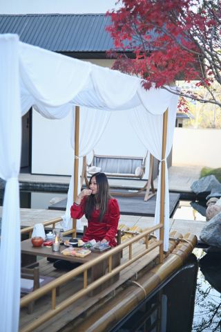 Nestled in the Wuyi Mountains, I truly felt like I was living inside the world described in "Ode to the Red Cliff."

This idyllic guesthouse I stayed at in Wuyi Mountain transported me back to the poetic realm of "drifting in a small boat, raising a gourd cup to toast each other!"

LeYe Private Courtyard truly embodies the essence of mountain poetry. Each villa boasts its own private courtyard nestled within a villa complex surrounded by mountains and water. Stone walls and flowers adorn the entrance, koi swim leisurely in the pond, and century-old camphor trees provide ample shade. Stepping outside reveals mist-shrouded peaks, and you're awakened by birdsong in the morning and surrounded by a sky full of stars at night. Falling asleep to the mountain breeze, even the air is filled with the sweet scent of grass and trees.

The log cabin-style rooms are incredibly comforting. The mattresses are soft and plush, and the rooms have bathtubs. Soaking in the tub while gazing at the mountain views instantly washes away all fatigue! There's also a smart control system; just say "Tmall Genie" to control the lights, curtains, and even watch movies—it's incredibly high-tech!

My favorite part was drinking Wuyi rock tea on a bamboo raft. Sunlight filtered through the leaves, dappling the tea table, with rolling green mountains in front of me. It truly gave me a sense of relaxed tranquility, like a boat adrift on a tranquil river, detached from the world.

The butler service was also incredibly attentive. We received welcome fruit, a complimentary mini-bar, professional travel photography, and even free access to the card room, gym, and arcade games. Breakfast was freshly made with a wide variety of options. There was even an abandoned train nearby that looked fantastic for photos! Once you're here, you won't want to leave!