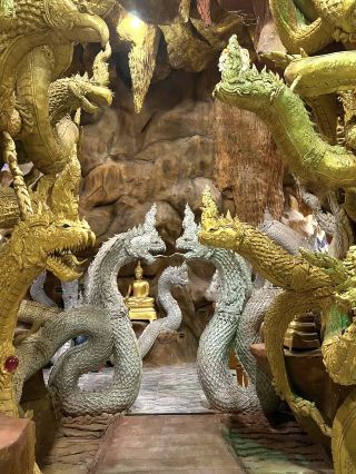 Pass through the colorful dragon tunnel to reach the mystical temple, Wat Maniwon
