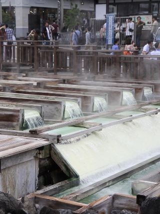 If you're a true onsen enthusiast, Yubatake (湯畑) in Kusatsu Onsen is a place you should visit at least once in your life. It's one of the three most famous onsen towns in Japan and has a unique character unlike any other.

⭐ Review: 9.8/10 For onsen lovers

Things that impressed me:

· ♨️ Natural hot spring water flows from its source at a rate of over 5,000 liters per minute, with steam rising throughout the day. The atmosphere is like being in an ancient onsen town.
· 🌙 At night, the town is illuminated, making Yubatake even more romantic than during the day. Many recommend visiting at both times.
· 🛁 There are free public onsen baths and foot baths (Ashiyu) to explore throughout the town.
· 👘 If you're staying at a ryokan, try wearing a yukata and strolling around the town for an authentic Japanese feel.
· 🍡 The surrounding area is full of snack shops, souvenir shops, cafes, and restaurants. You can easily spend the whole day exploring.

Key features of the hot spring water:

· It's sulfurous water with a distinctive smell.
· It's relatively acidic. It's renowned for the cleanliness and quality of its mineral water, but those with very sensitive skin may experience irritation.

Recommended Onsens You Shouldn't Miss:

· Sainokawara Rotenburo: A large outdoor onsen surrounded by nature, perfect for cooler weather.
· Watch the Yumomi performance: A traditional local custom of stirring hot water with paddles to lower its temperature.

Things to Know:

· The water is quite hot (42–45°C). If you're not used to it, enter gradually.
· It can get quite crowded on holidays and during winter.
· There's a strong sulfur smell, especially in the Yubatake area.