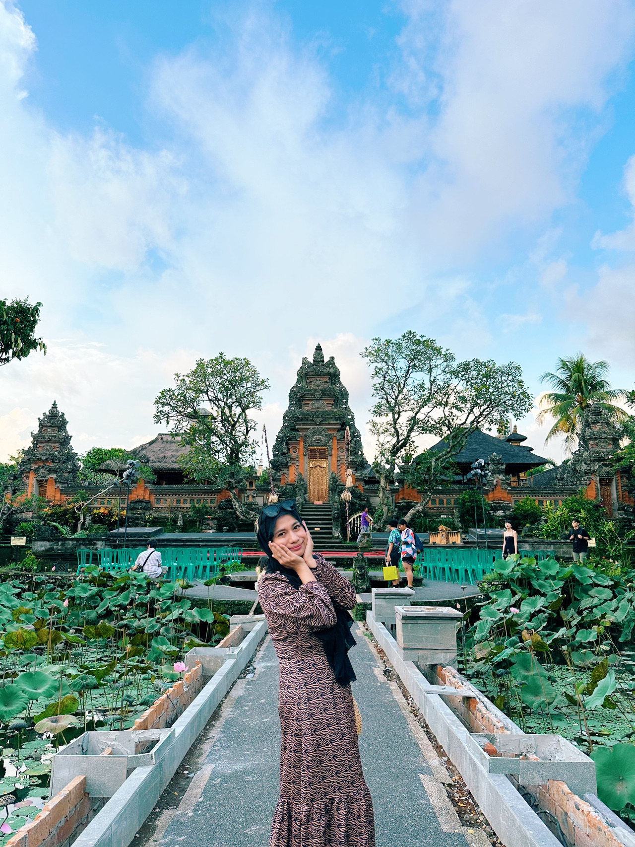 Jika kamu hanya punya satu hari penuh di Bali dan ingin mengunjungi tempat-tempat yang indah namun sarat makna, rute ini benar-benar sangat layak dicoba karena setiap pemberhentiannya menampilkan sisi Bali yang berbeda 🌿✨
Aku memilih untuk memulainya lebih awal di Handara Gate karena pagi hari adalah waktu terbaik di sini—lebih sepi pengunjung, udara lebih sejuk, dan kabut di sekitar perbukitannya membuat pemandangan terlihat semakin menawan 📸 Catatan: saat itu bulan Mei dan sedang musim hujan, jadi pastikan kamu selalu mengecek cuaca karena hampir seluruh wilayah Bali biasanya sering diguyur hujan.
Aku tahu banyak orang singgah ke sini utamanya untuk berfoto, tapi yang membuat tempat ini spesial adalah desain gerbang candi bentar tradisional Bali dengan latar belakang pegunungan, yang menjadikan tempat ini sangat ikonik. Kami harus membayar Rp50.000 untuk sesi foto selama 5 menit, tapi karena saat itu hujan lebat, kami tidak perlu menunggu lama dan lumayan bisa mendapatkan semua foto yang kami inginkan.
Tidak jauh dari sana, lanjutkan perjalanan ke Pura Ulun Danu Beratan🌊
Pura ini adalah salah satu destinasi yang pemandangan aslinya benar-benar sama persis seperti di foto, terutama karena letaknya yang berada tepat di tepi danau dan terkadang tampak seperti sedang mengapung.
Tiket masuknya seharga Rp75.000 per orang. Jika memungkinkan, usahakan datang lebih awal atau menjelang sore hari untuk menghindari keramaian.
Hal yang paling aku suka adalah suasananya: udaranya lebih sejuk, lingkungannya tenang, dan pura ini sendiri memiliki sejarah yang penting karena dibangun untuk menghormati dewi air. Hal ini juga menjelaskan mengapa air memegang peranan yang sangat penting dalam kehidupan masyarakat Bali.
Setelah dari Bedugul, lanjutkan perjalanan turun ke Ubud dan singgahlah di Puri Saren Agung (Ubud Palace) 👑
Tempat ini sangat mudah dikunjungi karena berada tepat di pusat Ubud, dan meskipun hanya singgah sebentar, kamu tetap bisa melihat sejarah kerajaan Bali melalui ukiran dan arsitekturnya.
Kemudian hanya dengan berjalan kaki sebentar, kunjungi Pura Taman Kemuda Saraswati 🌺
Aku suka betapa damainya pura ini meskipun berada di kawasan yang sibuk, dan kolam teratainya menjadikannya salah satu tempat paling cantik di area tersebut. Pura ini didedikasikan untuk Saraswati, dewi ilmu pengetahuan dan seni, yang sangat selaras dengan nuansa budaya Ubud.
Jika kamu masih punya waktu luang setelah mengunjungi semua tempat ini, kamu bisa menghabiskan lebih banyak waktu di Ubud untuk menjelajahi toko-toko lokal dan merasakan suasana khas setempat. Semoga panduan ini bisa membantu merencanakan harimu di Bali!