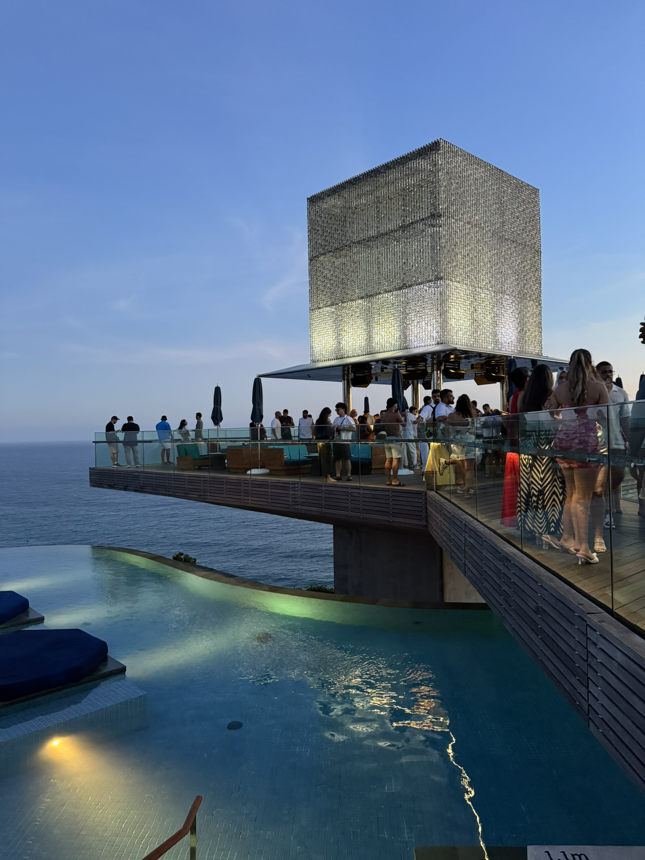 Savaya Bali terletak di tebing Uluwatu, sekitar 25–30 menit dari bandara Denpasar. Tempat ini menawarkan pemandangan Samudra Hindia yang menakjubkan — foto-foto dari sini selalu terlihat seperti adegan dari film.

Apa yang menanti Anda:
	• Kolam renang panoramik dengan pemandangan laut 🏝️
	• Kursi santai, cabana VIP, dan bar dengan koktail khas 🍸
	• Restoran masakan Jepang Sake no Hana 🍣
	• Pesta dengan DJ terkenal dunia dan set live 🎧
	• Suasana meriah dari matahari terbenam hingga larut malam 🌙

💡 Informasi penting:
	• 📅 Waktu terbaik untuk datang adalah pukul 16:00 untuk mendapatkan tempat dan menikmati matahari terbenam.
	• 💵 Biaya masuk berlaku (mulai dari 250–400k IDR, dapat bervariasi tergantung hari dan acara).
	• 👗 Dress code: smart casual / beach chic.
	• 🚗 Lebih mudah ke sana dengan taksi atau melalui Grab/GoJek — sebaiknya pesan perjalanan pulang terlebih dahulu.
	• 📷 Foto dan video diperbolehkan — konten di sini pasti 🔥

📍 Lokasi: Uluwatu, Kuta Selatan, Bali