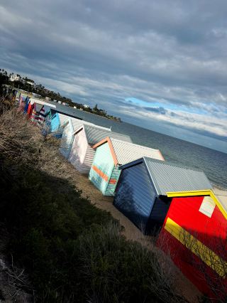 อยากไปเที่ยวเมลเบิร์นเพื่อเช็คอินใช่ไหม? ทริปเที่ยวไบรตันแบบไปเช้าเย็นกลับนั้นไม่ควรพลาดเลย! ครั้งนี้เราขอแนะนำหาดไบรตัน – สถานที่ที่มีชื่อเสียงที่สุดคือกระท่อมอาบน้ำสีสันสดใส (Brighton Bathing Boxes) ที่เรียงรายอยู่ริมทะเล ไม่ว่าจะวันไหนฟ้าครึ้มหรือแดดจัด ก็เหมาะสำหรับการถ่ายรูปอัพลง IG สุดๆ! คนรักการถ่ายภาพ แฟนภาพถ่าย และแฟนสถาปัตยกรรมจะต้องประทับใจ เพิ่มความพิเศษให้กับทริปของคุณด้วยบรรยากาศสบายๆ ของชายหาดออสเตรเลีย

🌈ไฮไลท์การเดินทางที่แนะนำ
สิ่งที่น่าสนใจที่สุดก็คือกระท่อมอาบน้ำสีสันสดใส พร้อมวิวทะเลธรรมชาติและสไตล์การพักผ่อนแบบพื้นเมืองออสเตรเลีย เป็นจุดถ่ายรูปที่สมบูรณ์แบบสำหรับ "การผสมผสานระหว่างมนุษย์และธรรมชาติ" ไม่ว่าคุณจะต้องการถ่ายภาพระยะไกล เก็บรายละเอียดทางสถาปัตยกรรมแบบมาโคร หรือแค่โพสท่าตามใจชอบกับเพื่อนๆ ก็ทำได้ง่ายๆ! และเปิดให้บริการตลอดทั้งปี คนไม่เยอะ ไม่ต้องกังวลเรื่องเวลา แนะนำให้ไปในตอนเช้าหรือตอนเย็นเพื่อหลีกเลี่ยงฝูงชนและพบกับแสงธรรมชาติที่สวยที่สุด

🏝️ กลยุทธ์การท่องเที่ยวบ้านพักล็อกเกอร์ริมหาดไบรตัน

1. บ้านพักอาบน้ำไบรตัน (Brighton Bathing Boxes) บ้านพักสีสันสดใส
ที่อยู่: Esplanade, Brighton VIC 3186 ออสเตรเลีย
เปิด: 24 ชั่วโมง 7 วันต่อสัปดาห์ ตลอดทั้งปี
แนะนำ: อาคารอันเป็นเอกลักษณ์ของรัฐวิกตอเรีย เริ่มต้นจากดีไซน์ดั้งเดิมในช่วงต้นศตวรรษที่ 20 ยังคงรักษารูปลักษณ์ดั้งเดิมและสไตล์ย้อนยุคไว้ แต่ละหลังมีสีและลวดลายที่เป็นเอกลักษณ์ ไม่ซ้ำใคร! แนะนำให้ถ่ายภาพมุมกว้างของชายทะเลจากระยะไกล จากนั้นถ่ายภาพระยะใกล้เพื่อสร้างปฏิสัมพันธ์กับบ้านพัก - ไม่ว่าจะนั่งอยู่หน้าบ้านหรือมองหาสีที่เหมาะสมเป็นฉากหลัง อย่ากลัวที่จะเลือกสีที่ตัดกัน!

2. หาดไบรตัน (Brighton Beach)
แนะนำ: เป็นชายหาดพักผ่อนยอดนิยมของชาวเมลเบิร์น มีน้ำใสและหาดทรายกว้าง เหมาะสำหรับเล่นกีฬา ปิกนิก และอาบแดด โดยเฉพาะช่วงสุดสัปดาห์จะมีครอบครัวชาวท้องถิ่นและสัตว์เลี้ยงมาถ่ายรูปกันมากมาย ขอแนะนำให้ลองเดินเล่นบนหาดทรายในยามเย็น สัมผัสลมทะเลเย็นสบาย

3. ร้านอาหารและคาเฟ่ริมทะเล
ร้านอาหารแนะนำ: The Baths Middle Brighton
ที่อยู่: 251 Esplanade, Brighton VIC 3186
แนะนำ: ร้านอาหารทันสมัยตั้งอยู่ติดกับชายหาด คุณสามารถเพลิดเพลินกับอาหารทะเลสไตล์วิคตอเรียน เบอร์เกอร์ และบรันช์ กระจกบานใหญ่จากพื้นจรดเพดานช่วยให้คุณรับประทานอาหารได้อย่างช้าๆ พร้อมชมวิวทะเล เหมาะอย่างยิ่งสำหรับการพักผ่อนหลังจากถ่ายภาพ!

📸 ความรู้สึก ・ สรุปเคล็ดลับ
ขอแนะนำอย่างยิ่งให้จองอย่างน้อย 2 ชั่วโมงเพื่อเพลิดเพลินกับการเช็คอินและประสบการณ์ชีวิต แม้ว่าท้องฟ้าจะครึ้มเล็กน้อย แต่เนื่องจากกระท่อมมีสีสันสดใส ภาพถ่ายจึงไม่น่าเบื่อและมีบรรยากาศลึกลับและเรียบง่าย! หากต้องการถ่ายภาพสวยๆ สามารถใช้ประโยชน์จากแสงธรรมชาติได้ เมื่ออยู่บน "ทราย" โปรดระวังอย่าวางกล้องและโทรศัพท์มือถือลงบนทรายโดยตรง กระท่อมสำหรับแต่งตัวใช้สำหรับการถ่ายภาพเท่านั้น ไม่อนุญาตให้ใช้งาน ช่วงเช้าหรือบ่ายคนน้อยที่สุด ทำให้การหาที่เที่ยวกลางคืนง่ายขึ้นครึ่งหนึ่ง!

🚗คำแนะนำการเดินทาง
จากใจกลางเมืองเมลเบิร์น นั่งรถไฟสาย Sandringham ไปลงที่สถานี Brighton Beach ลงจากรถไฟแล้วเดินประมาณ 10 นาทีก็จะถึงชายหาด หากขับรถมาเอง มีที่จอดรถสาธารณะอยู่ใกล้ชายหาด แต่ช่วงสุดสัปดาห์อาจเต็มได้ง่าย แนะนำให้มาถึงแต่เช้า

🍴คำแนะนำเรื่องอาหาร
มีร้านกาแฟและร้านอาหารทะเลให้เลือกมากมาย คุณสามารถหาร้านกาแฟที่ถูกใจได้ตาม Esplanade เพื่อดื่มกาแฟ Flat White สักแก้ว

🧳สิ่งของจำเป็นที่ควรเตรียม
1. แนะนำให้นำแว่นกันแดด/สเปรย์กันแดด เสื้อแจ็คเก็ตบางๆ (เพราะกลัวลมทะเล)

2. สวมรองเท้าที่ทำความสะอาดง่าย เพราะมีทรายบนชายหาดเยอะ และต้องเปลี่ยนจุดถ่ายรูปบ่อยๆ

3. กล้องถ่ายรูปและโทรศัพท์มือถือที่ชาร์จแบตเตอรี่เต็มแล้ว ~

#คู่มือเมลเบิร์น #ถ่ายรูปที่ Brighton Hut #ความงามของชายหาด #ท่องเที่ยวคนเดียว #ชีวิตช้าๆในเมือง