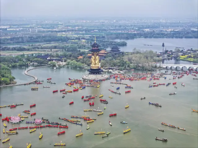 Thousands of poles and myriad paddles stir the waters of Qinhu Lake, as hundreds of boats race with the spring tide