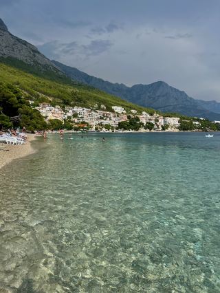 🏝️ Brela: Crystal Clear Waters on Croatia’s Dalmatian Coast 🇭🇷✨

Located between Split and Makarska, Brela is a beautiful seaside destination famous for its turquoise waters, peaceful beaches, and the stunning backdrop of the Biokovo Mountains. With its combination of pine forests, rocky coastline, and clear Adriatic Sea, it is one of the most scenic places to enjoy the natural beauty of Croatia’s coast. 🌊🌲

✨ Things to do in Brela:
· 🏖️ Relax on Punta Rata Beach, one of the most famous beaches in Croatia, known for its white pebbles, crystal-clear water, and the iconic Brela Stone rising from the sea
· 🚶 Walk along the coastal promenade connecting Brela’s beaches, surrounded by pine trees and incredible sea views
· 🤿 Swim and snorkel in the transparent Adriatic waters to discover the rocky coastline beneath the surface
· 🌅 Enjoy sunset views over the islands of the Adriatic, one of the most beautiful moments of the day in Brela
· 🥾 Explore nearby nature trails or combine your visit with the impressive Biokovo Nature Park

💡 Travel tips:
· 🚗 Brela is about 50 minutes by car from Split and around 15 minutes from Makarska, making it a great stop on a Dalmatian coast road trip
· 👟 The coastline has many stairs and slopes, so comfortable shoes are recommended, especially when moving between beaches
· 📅 Visit in June or September for warm weather, clear water, and fewer crowds compared to peak summer months
· 🅿️ Parking can be limited during July and August, so arriving early is recommended

Brela is the perfect place for travelers who love relaxing by the sea while still having incredible landscapes around them. With its combination of beaches, pine forests, and mountain views, it captures the essence of the Dalmatian coast. 🇭🇷🌊

#Brela #Croatia #DalmatianCoast #AdriaticSea #CroatiaTravel #PuntaRata #BeachLovers #RoadTripCroatia #ScenicSpotGuide