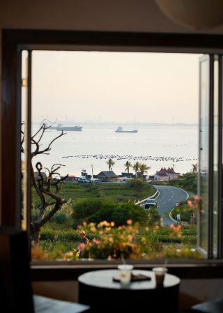 Pingtan Heping Coffee | A cream-colored building frames the S-shaped bay view, where the aroma of coffee hides a slow pace of life.