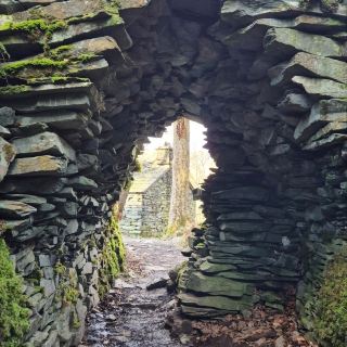 If you’re looking to trade the drizzly hills of Cumbria for something that feels like a discarded set piece from The Lord of the Rings, look no further than Cathedral Cavern.

Tucked away in the Little Langdale valley, this isn't your average "wet hole in the ground." It’s a massive, hand-hewn slate cathedral that manages to be both hauntingly beautiful and slightly intimidating.

⛰️ The Vibe: Industrial Gothic
Imagine a giant took a chisel to a mountain and decided to create a moody underground lair. The cavern is dominated by a 40-foot pillar of rock that holds up the roof.

The Entrance: You have to walk through a 100-meter-long, pitch-black tunnel. It’s the perfect moment to realize your phone flashlight is actually quite pathetic.

The "Window": High up in the main chamber, a natural opening lets in shafts of light that make everyone look like they’re about to deliver a dramatic monologue.

Pro Tips for the Prepared Explorer:

Mind Your Head: If you’re over 5'10", the entrance tunnel will remind you of your height in the least pleasant way possible.

Waterproof Everything: The floor of the tunnel is often a shallow stream. Unless you enjoy the "wet wool sock" aesthetic, wear boots.

The Echo: It’s mandatory to let out a small "hello" just to hear the cavern judge you in surround sound.

#LakeDistrict #cave #explorer 
