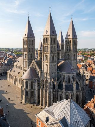 ⛪ Tournai Cathedral

Beautiful and powerful from the first glance, the Basilica of Our Lady of Tournai (Notre-Dame de Tournai) is one of the most outstanding sacred architectural landmarks in Tournai, Belgium. 🕊️✨ Its majestic form and five towering spires reflect the impressive grandeur of medieval art.

Upon closer inspection, the charm of Romanesque architecture beautifully blended with Gothic details is evident. The building's lines are strong yet delicate, as if stories from the past are preserved in every corner of the cathedral. 🤍

The interior is even more captivating, with its tall columns, arches, and tranquil spaces creating an atmosphere of solemnity and elegance. It's perfect for a leisurely stroll, allowing yourself to absorb the beauty of architecture that has stood the test of time.

Tournai Cathedral is not just an important religious site; it's a record of art, history, and faith, remaining beautiful beyond time. 🌿

“Some beauty needs no words… simply standing before it, you can feel the story of time.”