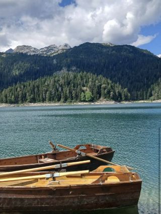 Rowing a Wooden Skiff Across the Mirror-Like Lake