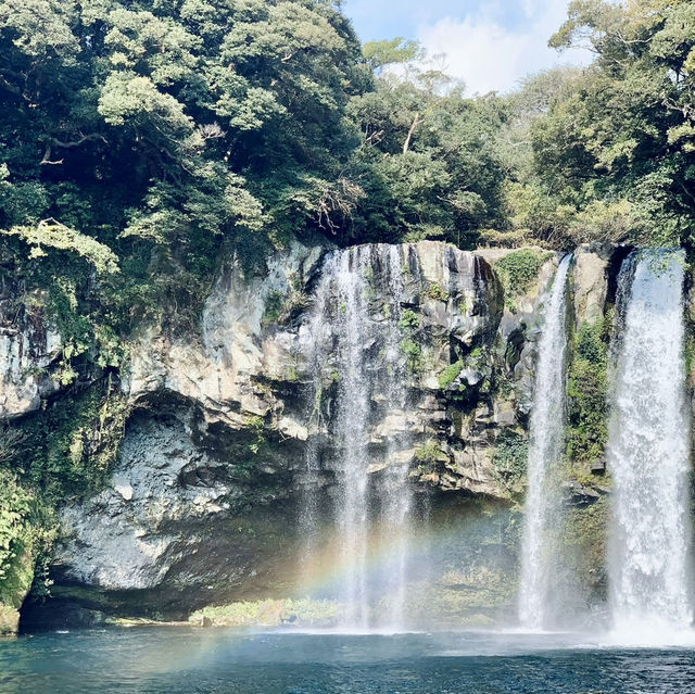 "Cheonjiyeon Waterfall: A Stunning View with a Rainbow on Jeju Island"