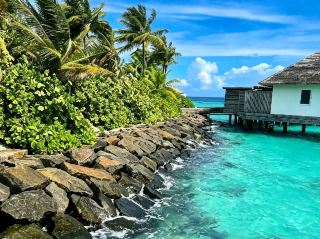 Walking along the iconic overwater walkways at Waldorf Astoria Maldives Ithaafushi